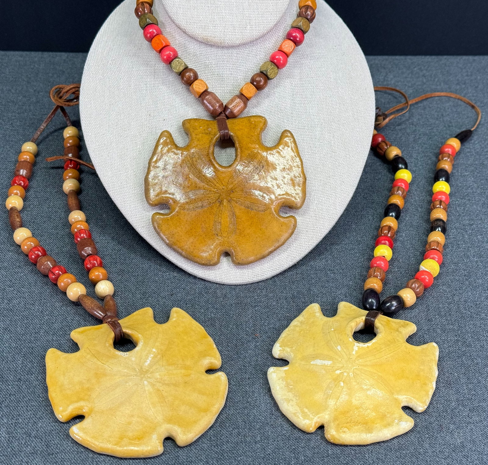 Cover-Up Creations Arizona sand dollar wooden beads leather strap necklace. Lot of 3: Cover-Up Creations Arizona sand dollar wooden beads leather strap necklace. Unmarked. The paper and the label in the last 2 pictures are not included. For measures please refer to the pictures taken w