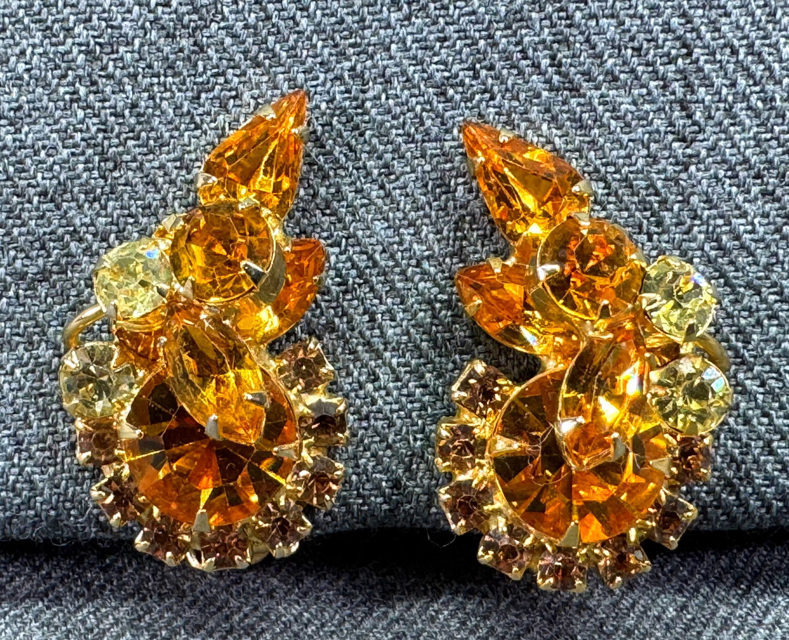 Vintage Juliana style amber color & clear crystals goldtoned clip earrings.: Vintage Juliana style amber color & clea crystals goldtoned clip earrings. Unmarked. For measures please refer to the pictures taken with a measuring tape. Weight:14 Grams IN HOUSE Estimated* SHIPPING