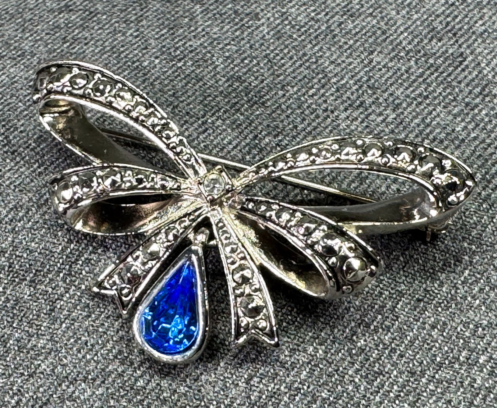 Vintage Avon birthstone September bow brooch pin. Blue crystal, silvertoned metal: Vintage Avon birthstone September bow brooch pin. Blue crystal, silvertoned metal. Marked. For measures please refer to the pictures taken with a measuring tape. Weight: 12 Grams. IN HOUSE Estimated* 
