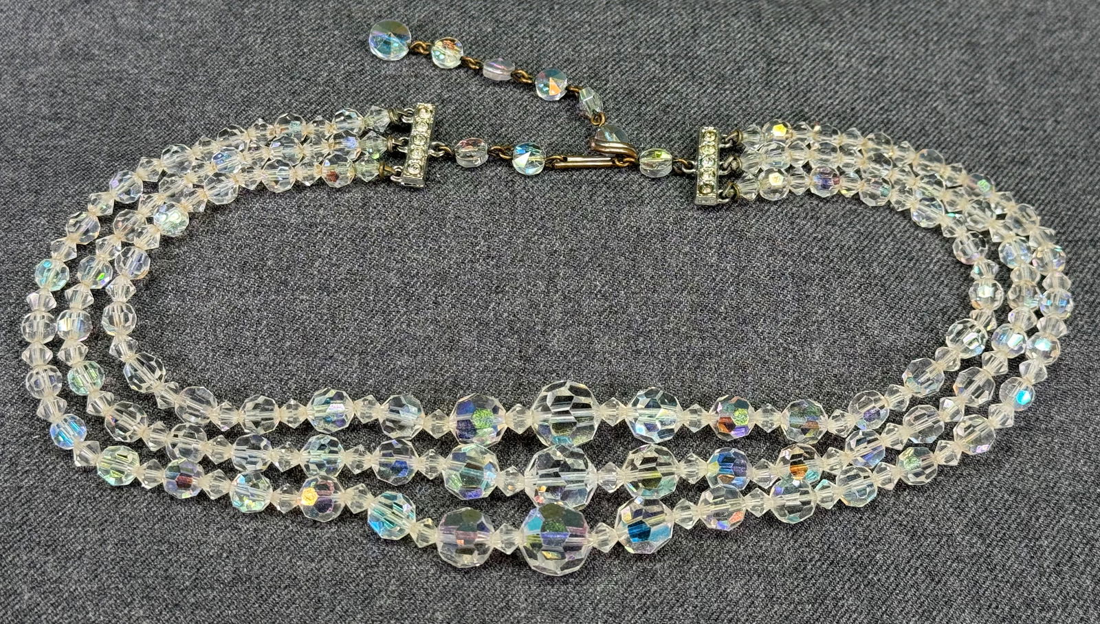 Vintage AB clear faceted crystals beaded 3 strands collar necklace. Jeweled clasp: Vintage AB clear faceted crystals beaded 3 strands collar necklace. Jeweled clasp . Unmarked. For measures please refer to the pictures taken with a measuring tape. Weight: 64 Grams. IN HOUSE Estimate