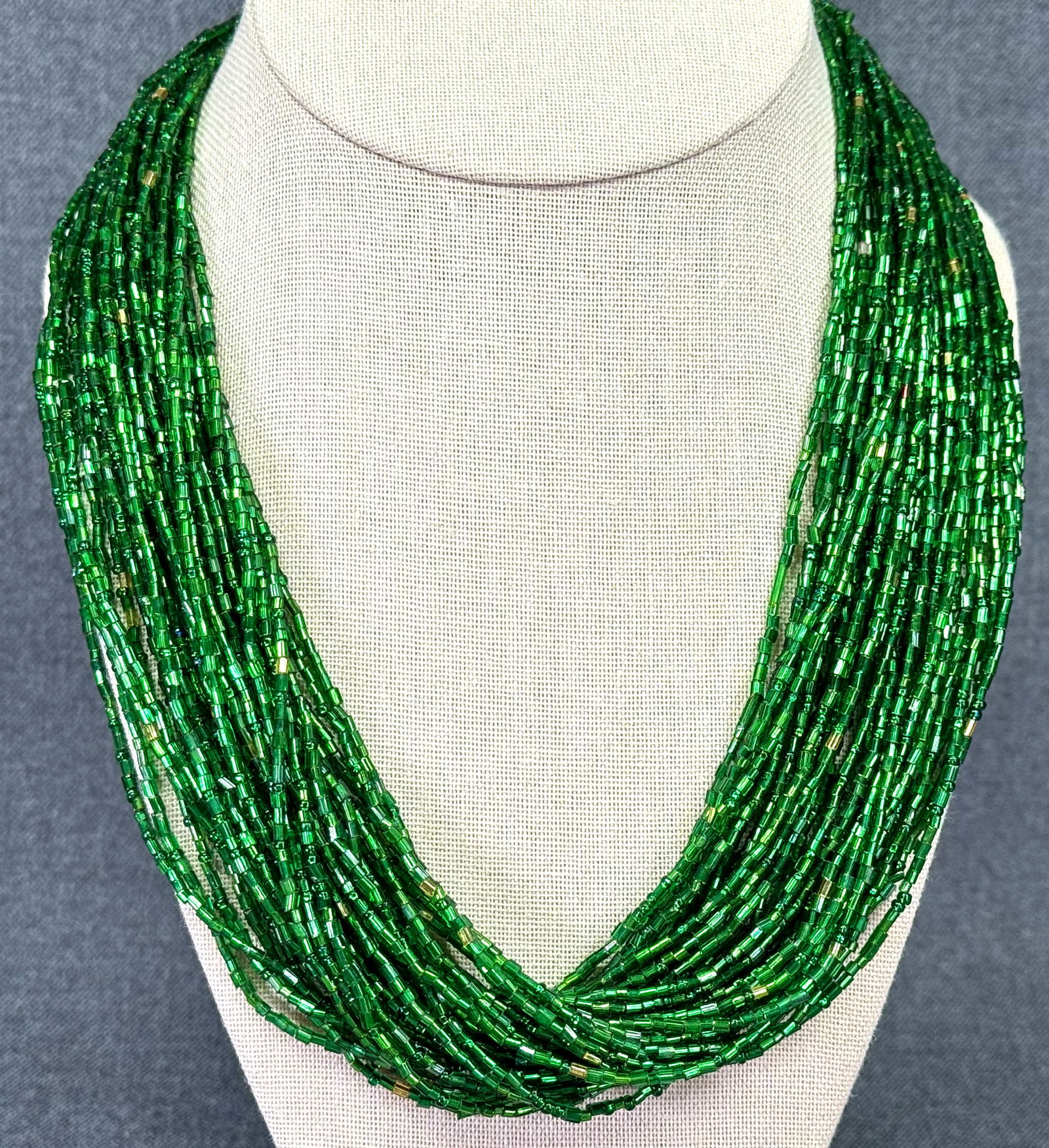 Vintage glass green beads multi strand necklace: Vintage glass green beads multi strand necklace. Unmarked. For measures please refer to the pictures taken with a measuring tape. Weight: 42 Grams. IN HOUSE Estimated* SHIPPING & HANDLING COST WITHIN