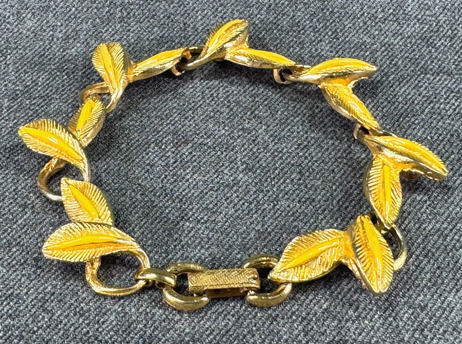 Vintage Trifari style yellow enamel goldtoned metal leaves bracelet: Vintage Trifari Style yellow enamel goldtoned metal leaves bracelet. Unmarked. For measures please refer to the pictures taken with a measuring tape. Weight: 26 Grams. IN HOUSE Estimated* SHIPPING & H