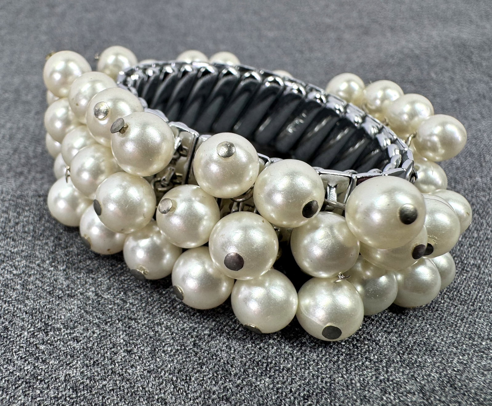Vintage Japanese pearly beads dangles silvertoned accordion expandable bracelet: Vintage Japanese pearly beads dangles silvertoned accordion expandable bracelet. Marked Japan. For measures please refer to the pictures taken with a measuring tape. Weight: 47 Grams. IN HOUSE Estimat