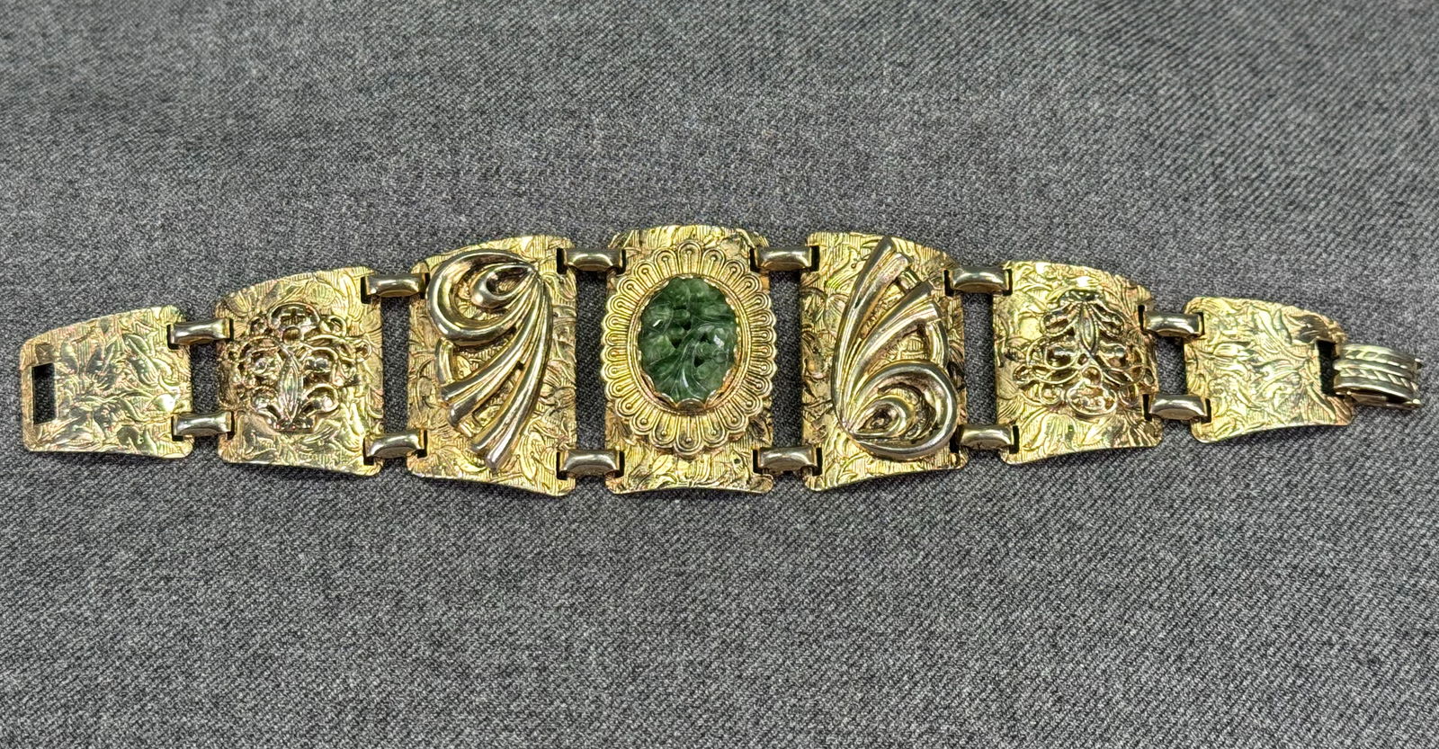 Vintage carved Jade medallion decorated goldtone metal bracelet: Vintage flowers and leaves carved green Jade medallion decorated goldtone metal bracelet. Unmarked. For measures please refer to the pictures taken with a measuring tape. Weight: 45 Grams. IN HOUSE Es