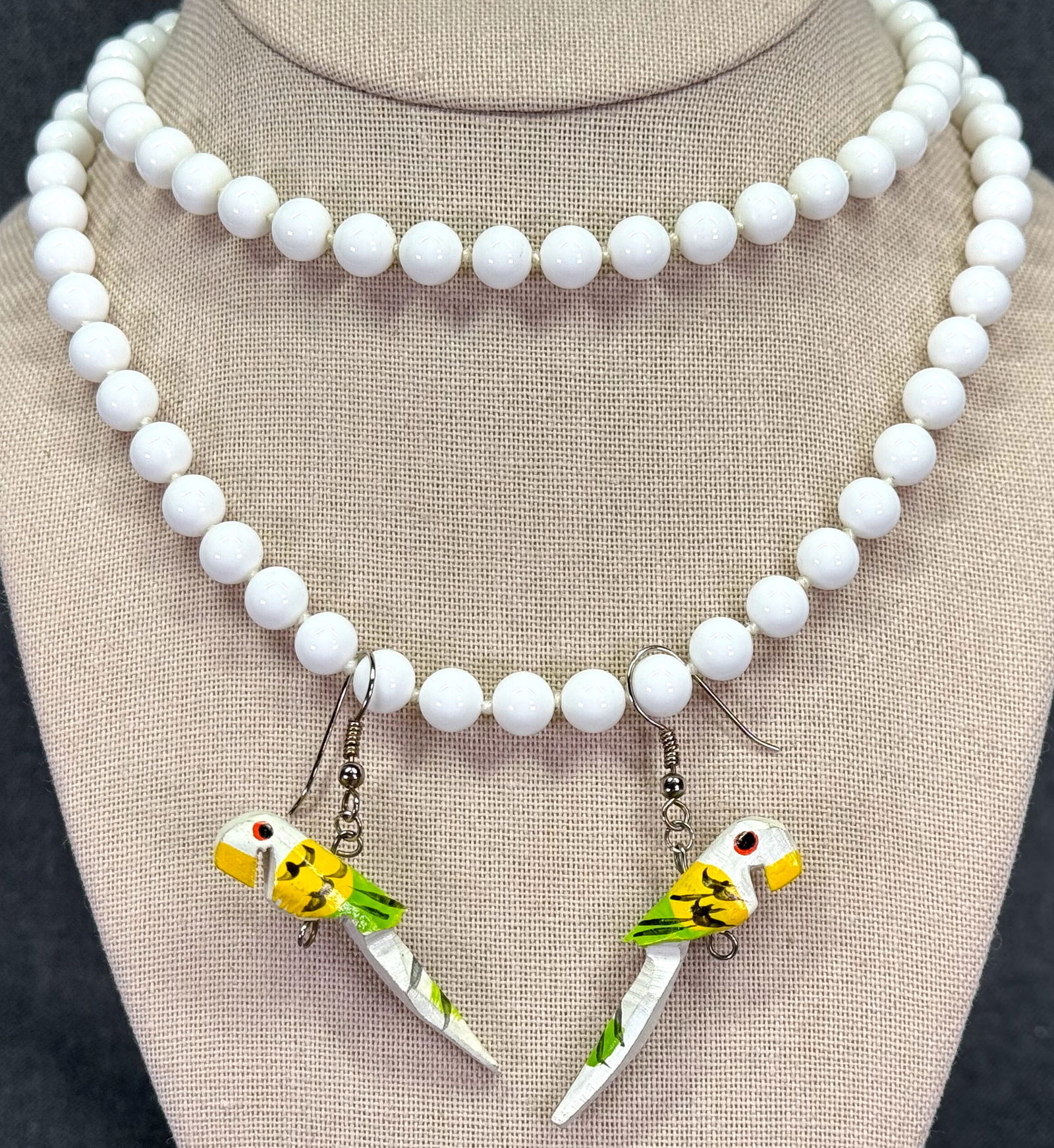 Vintage folk art hand painted wood parrot earrings & Monet milky glass beaded necklace: Vintage folk art hand painted wood parrot hook earrings & Monet white milky glass beaded necklace. The necklace is marked Monet on the clasp. Earrings are Unmarked. For measures please refer to the pi