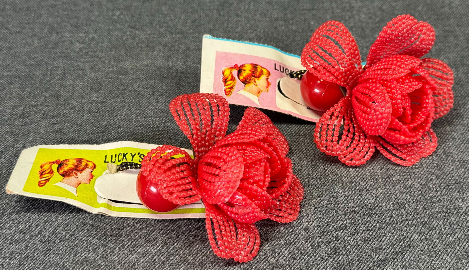 Vintage red plastic flower elastic band pony tail hair holder. Unused in card. Lot of 2: Vintage red plastic flower elastic band pony tail hair holder. Unused in card. For measures please refer to the pictures taken with a measuring tape. IN HOUSE Estimated* SHIPPING & HANDLING COST WITHI