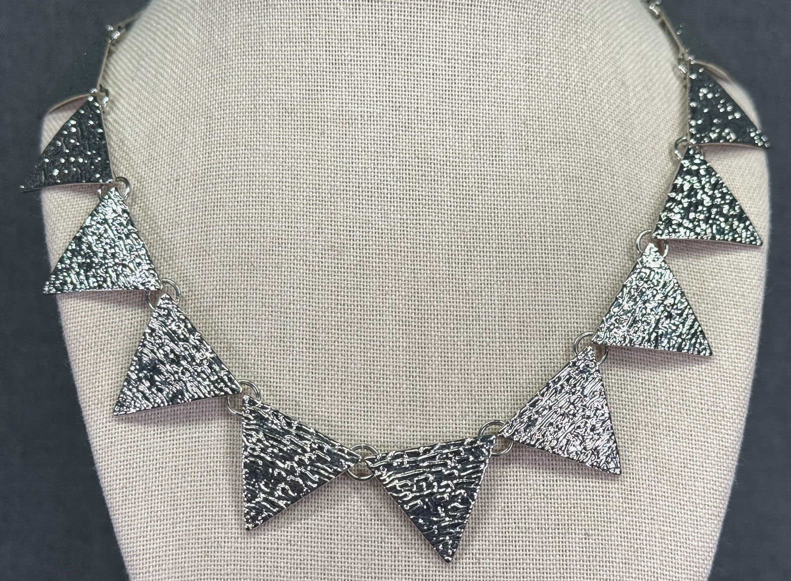 Vintage textured silvertoned metal triangles collar necklace: Vintage textured silvertoned metal triangles collar necklace. Unmarked. For measures please refer to the pictures taken with a measuring tape. Weight: 27 Grams. IN HOUSE Estimated* SHIPPING & HANDLING
