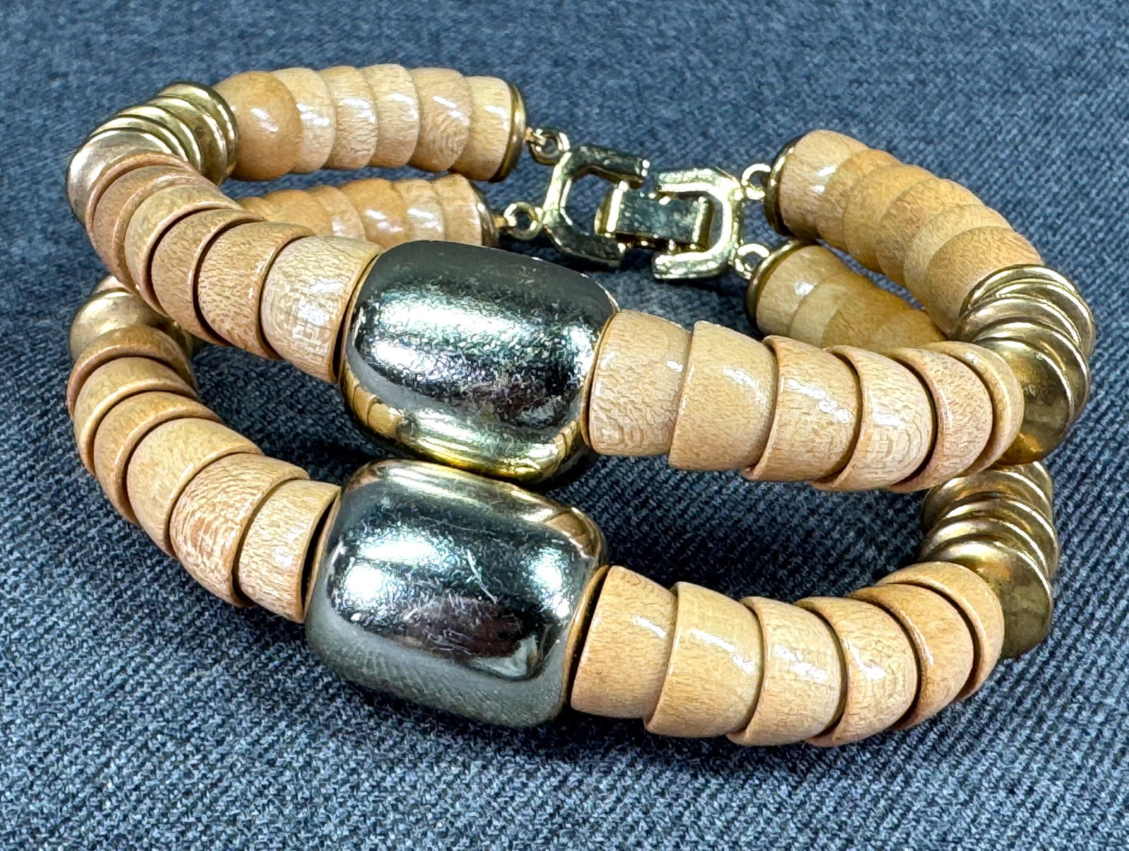 Vintage boho goldtoned metal wooden beads two strands bracelet: Vintage boho goldtoned metal wooden beads two strands bracelet. Unmarked. For measures please refer to the pictures taken with a measuring tape. Weight: 23 Grams IN HOUSE Estimated* SHIPPING & HANDLIN