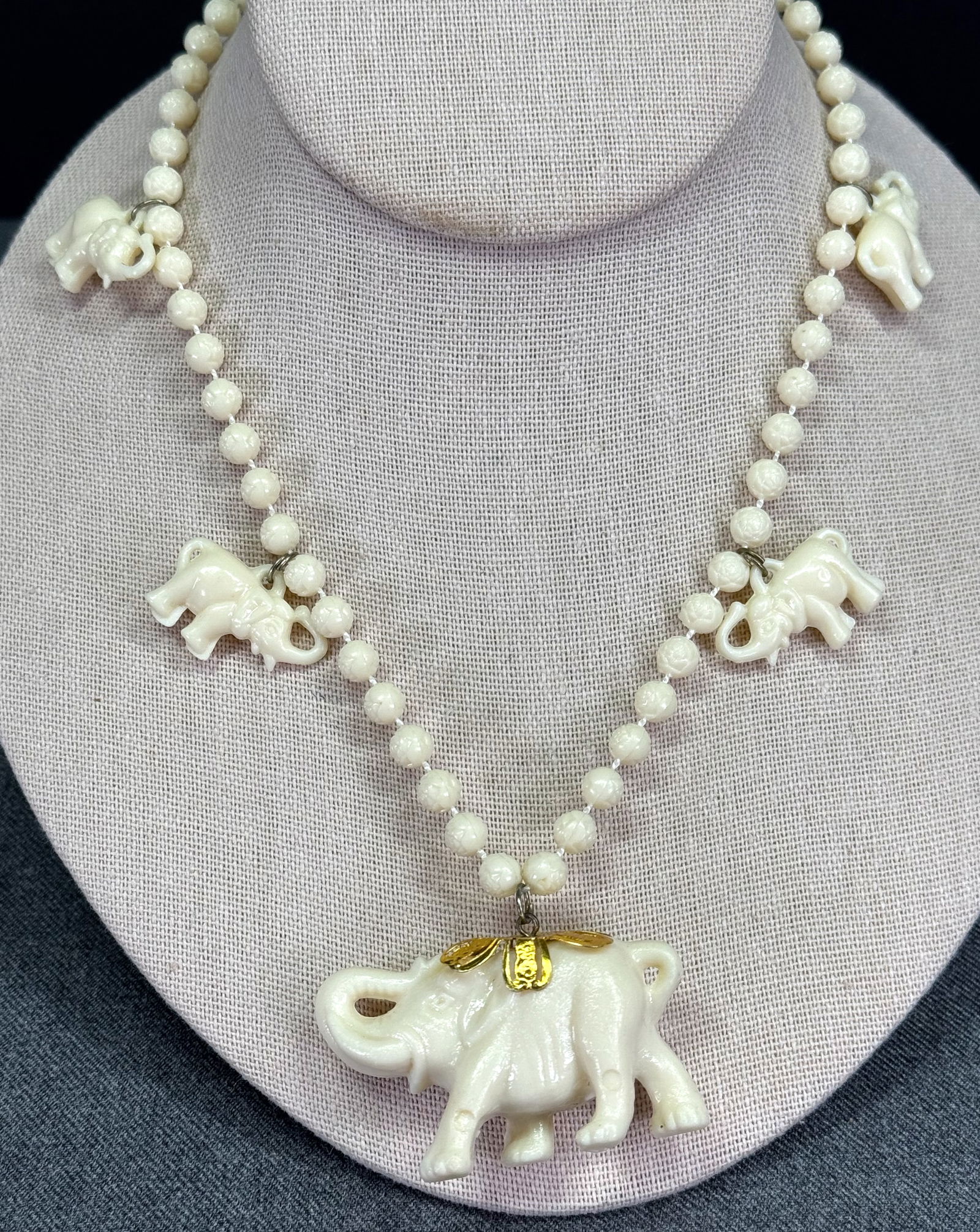 Vintage creamy thermoplastic elephant dangles beaded necklace: Vintage creamy thermoplastic elephant dangles beaded necklace. Unmarked. For measures please refer to the pictures taken with a measuring tape. Weight: 23 Grams. IN HOUSE Estimated* shipping and handl