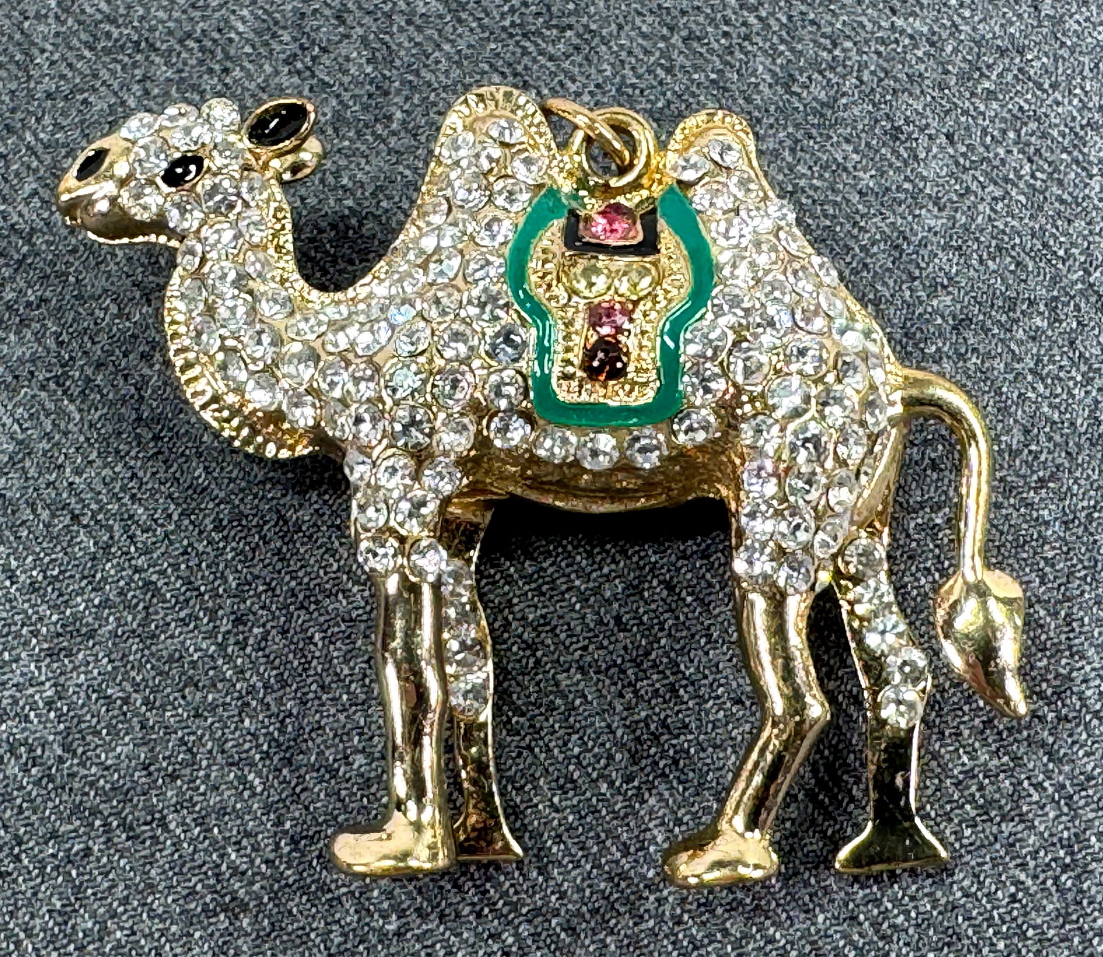 Vintage crystals enamel goldtoned metal camel pendant: Vintage crystals enamel goldtoned metal camel pendant Unmarked. For measures please refer to the pictures taken with a measuring tape. Weight: 30 Grams. IN HOUSE Estimated* SHIPPING & HANDLING COST WI