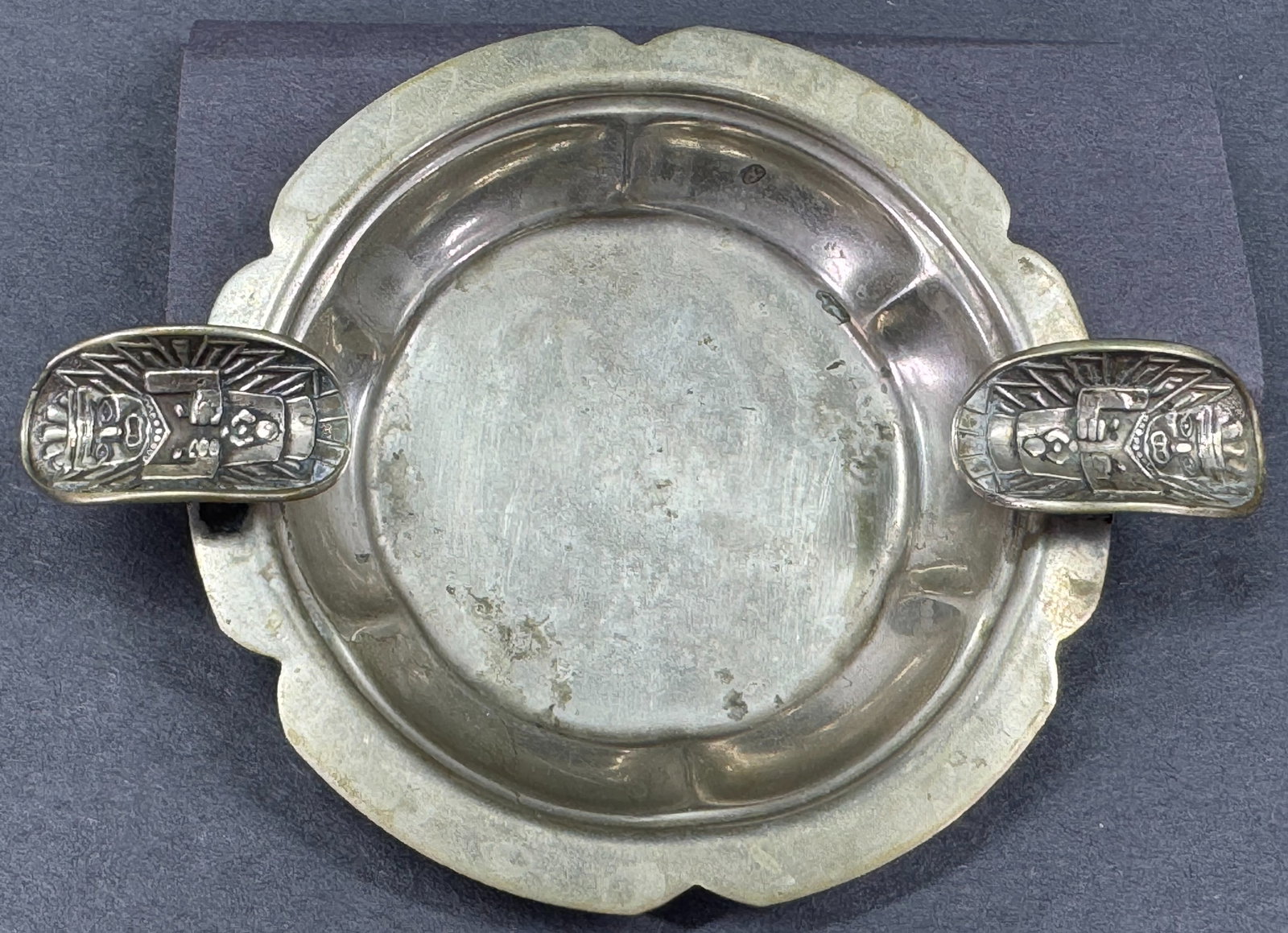 Vintage Ethnic design on cigarette holders silvertone metal ashtray.: Vintage Ethnic design on cigarette holders silvertone metal ashtray. For measures please refer to the pictures taken with a measuring tape. Weight: 28 Grams. This is a NO RESERVE AUCTION: there are no