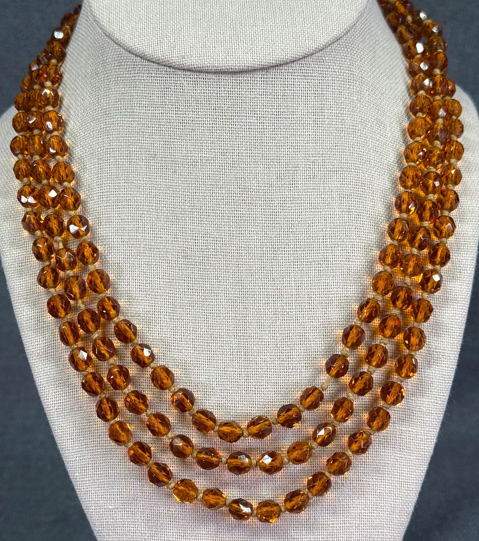 Vintage flapper hand knotted in between faceted amber color glass beads necklace: Vintage flapper hand knotted in between orange glass beads necklace. Unmarked. For measures please refer to the pictures taken with a measuring tape. Weight: 60 Grams. IN HOUSE Estimated* SHIPPING & H