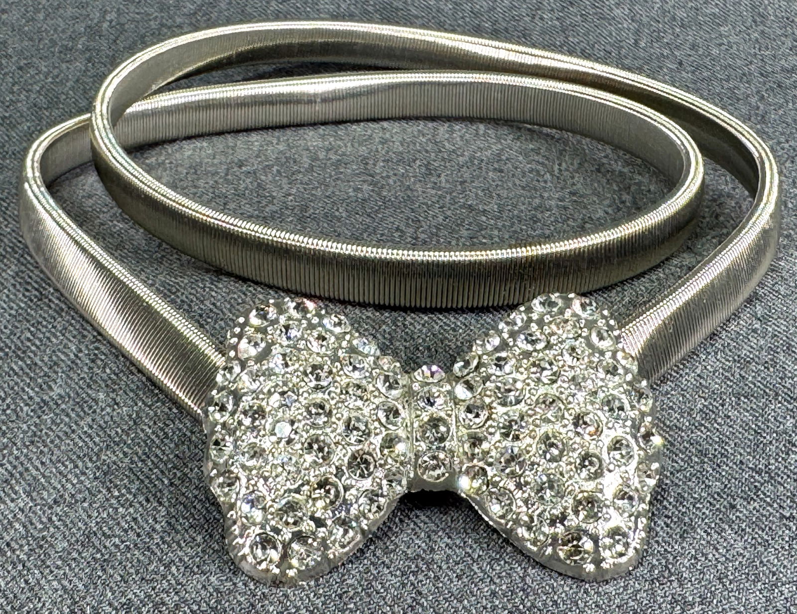 Vintage clear crystal silvertoned bow buckle expandable strap belt: Vintage clear crystal silvertoned bow buckle expandable strap belt. Unmarked. For measures please refer to the pictures taken with a measuring tape. Weight: 80 Grams IN HOUSE Estimated* SHIPPING & HAN