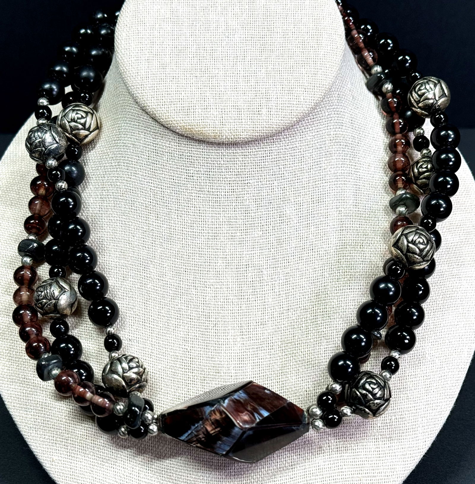 Vintage marquetry MOP medallion 3 strands plastic, glass & metal necklace.: Vintage marquetry MOP medallion 3 strands plastic, glass & metal necklace. Unmarked. Oversized silvertone metal clasp. For measures please refer to the pictures taken with a measuring tape. Weight: 32