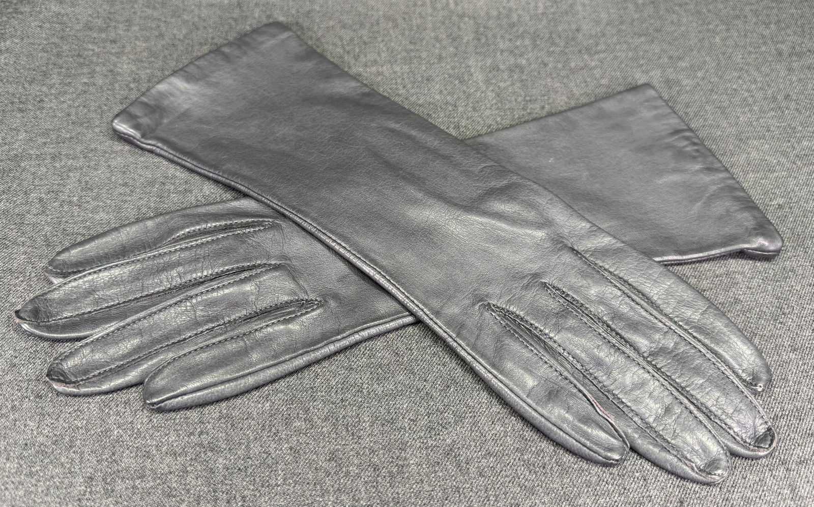 Vintage genuine gray leather gloves. Size 7 . Lined in silk: Vintage genuine gray leather gloves. Size 7 . Lined in silk. For measures please refer to the pictures taken with a measuring tape. IN HOUSE Estimated* SHIPPING & HANDLING COST WITHIN THE U.S. : $7 WE