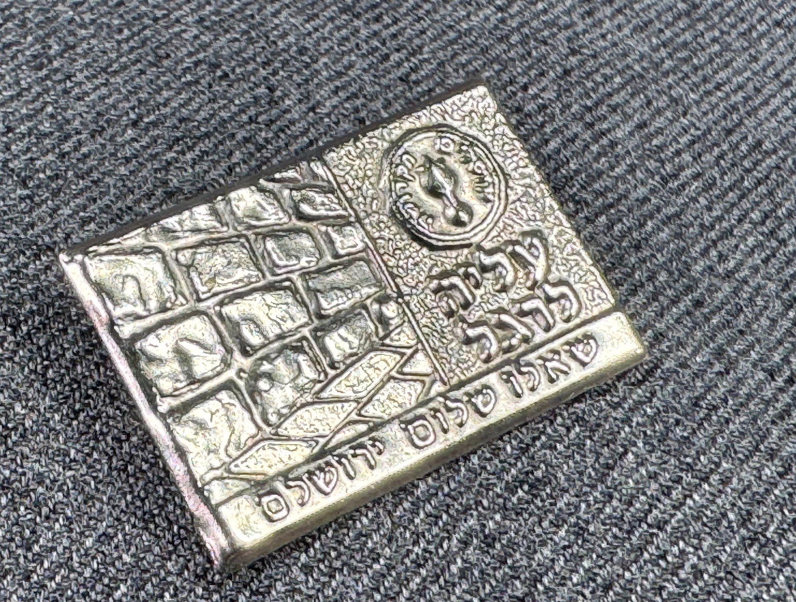 Vintage Jerusalem wailing wall silvertoned metal brooch pin: Vintage Jerusalem wailing wall silvertoned metal brooch pin. Unmarked. For measures please refer to the pictures taken with a measuring tape. Weight: 1 Grams IN HOUSE Estimated* SHIPPING & HANDLING CO