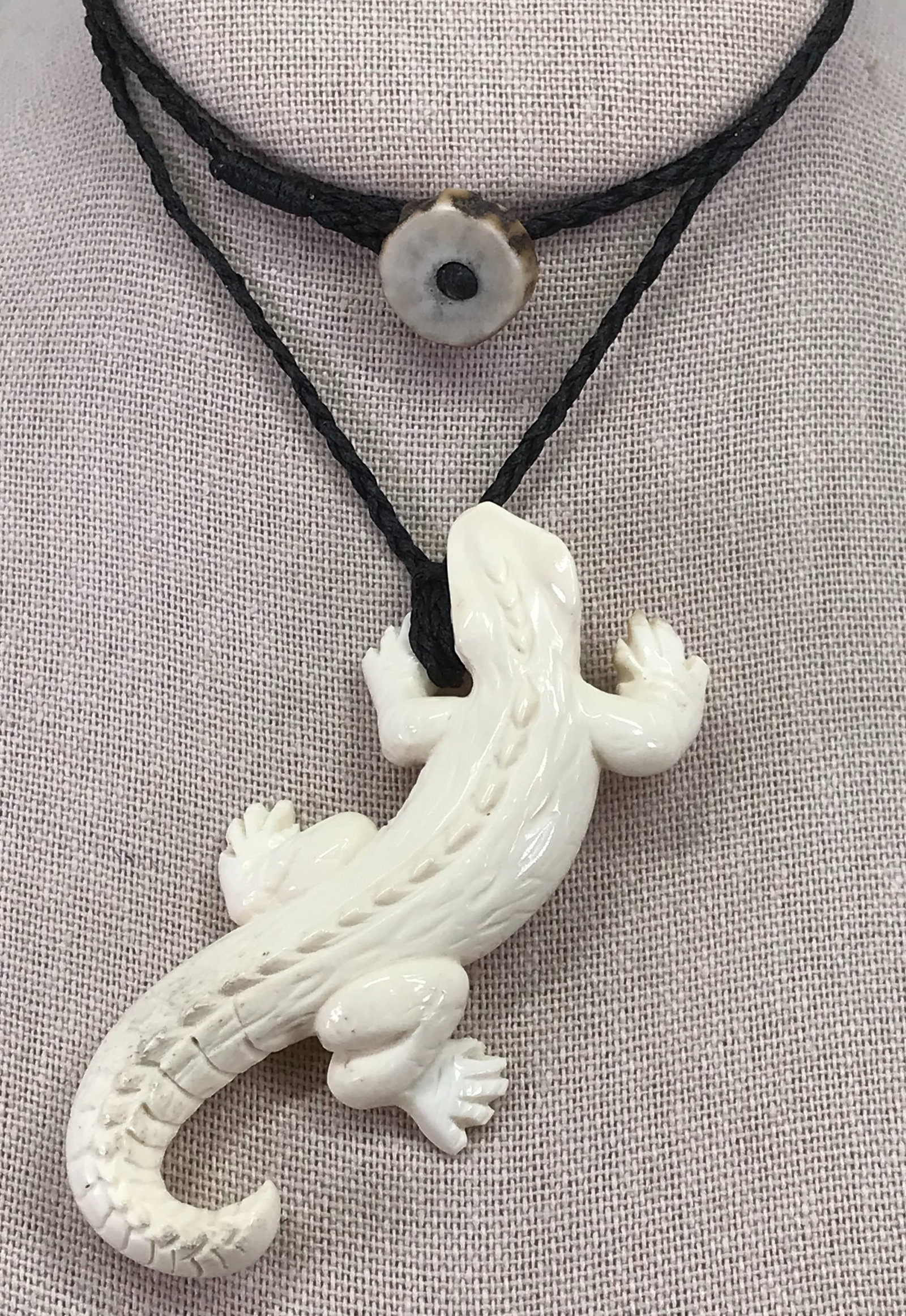 Carved deer antler alligator shaped pendant.: Carved deer antler alligator shaped pendant. Unmarked. Black waxed string and antler bead clasp. The pendant measures 3 x 1 1/2 inches, the strap 20 inches long. Weight: 21 Grams. This is a NO RESERVE