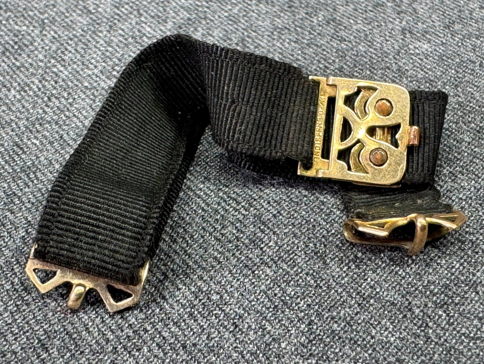 Antique Pat 1919 gold-filled clasp black grosgrain ribbon watch band: Antique Patented May 13, 1919 gold-filled clasp black grosgrain ribbon watch band. Marked. For measures please refer to the pictures taken with a measuring tape. Weight: 3 Grams. IN HOUSE Estimated* S