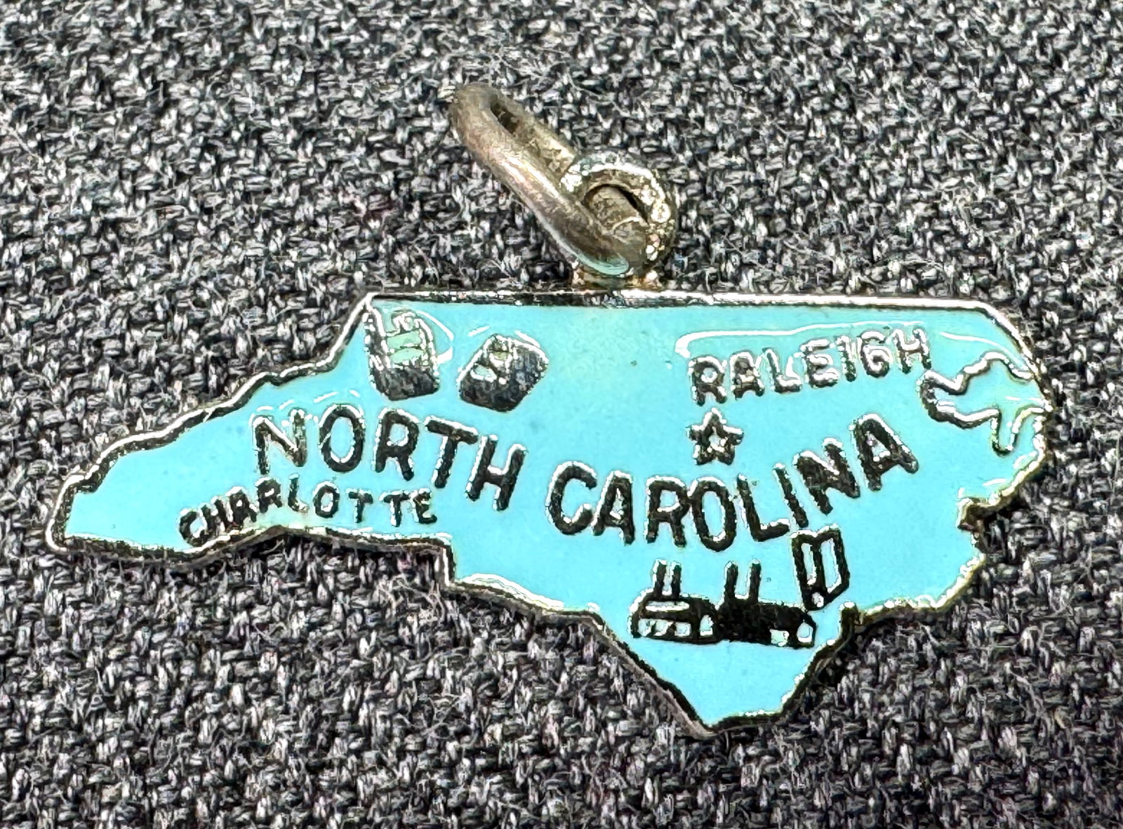 Vintage North Carolina Souvenir Sky-Blue Enamel Sterling Silver Pendant Bracelet Charm: Vintage North Carolina Souvenir Sky-Blue Enamel Sterling Silver Pendant Bracelet Charm. Marked. For measures please refer to the pictures taken with a measuring tape. Weight: 1.53 Grams IN HOUSE Estim