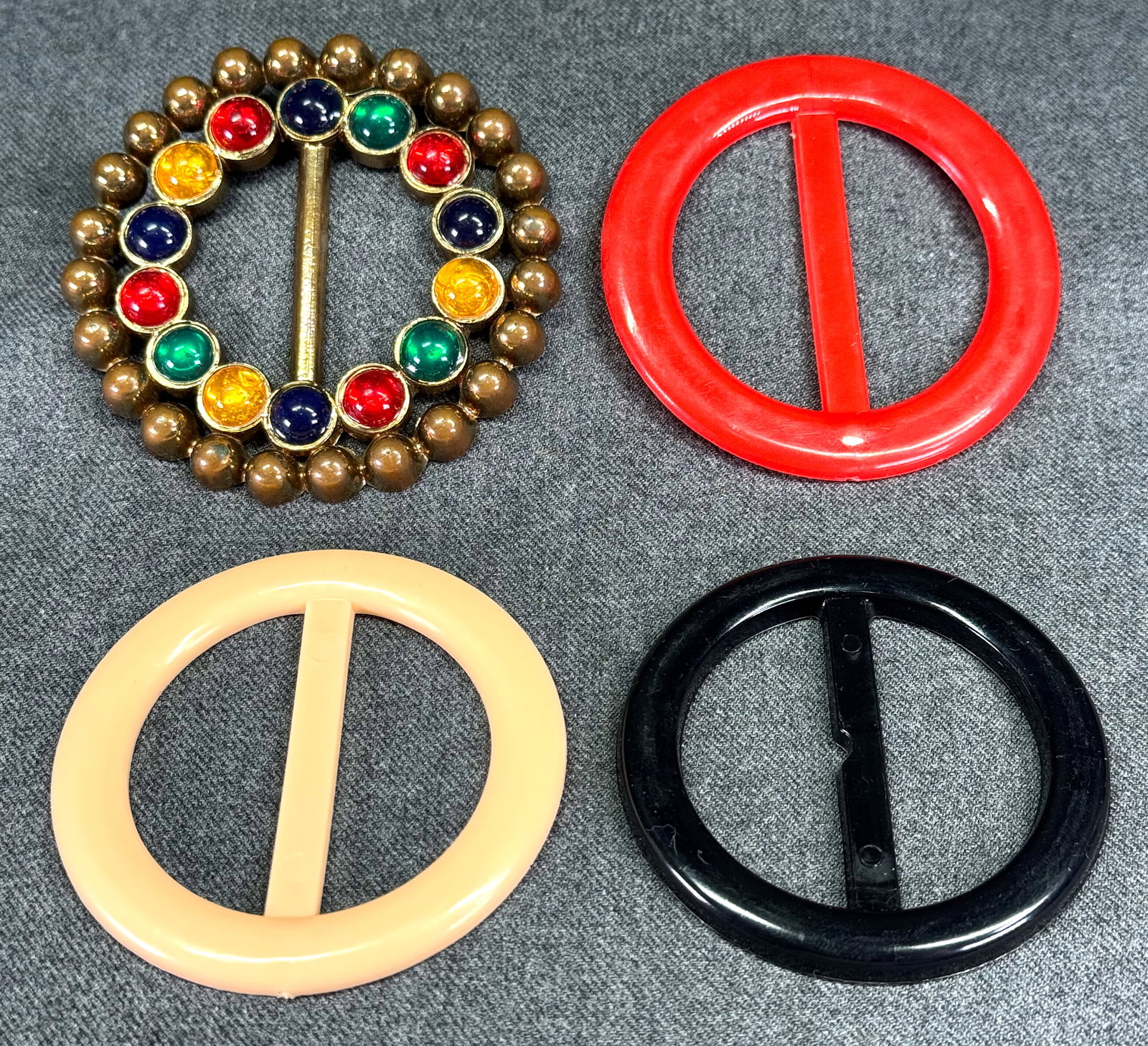 Vintage red, black, salmon, color cabs goldtone plastic belt buckle.: Vintage red, black, salmon, color cabs goldtone plastic belt buckle. Marked Taiwan. For measures please refer to the pictures taken with a measuring tape. Weight: 40 Grams . IN HOUSE Estimated* shippi