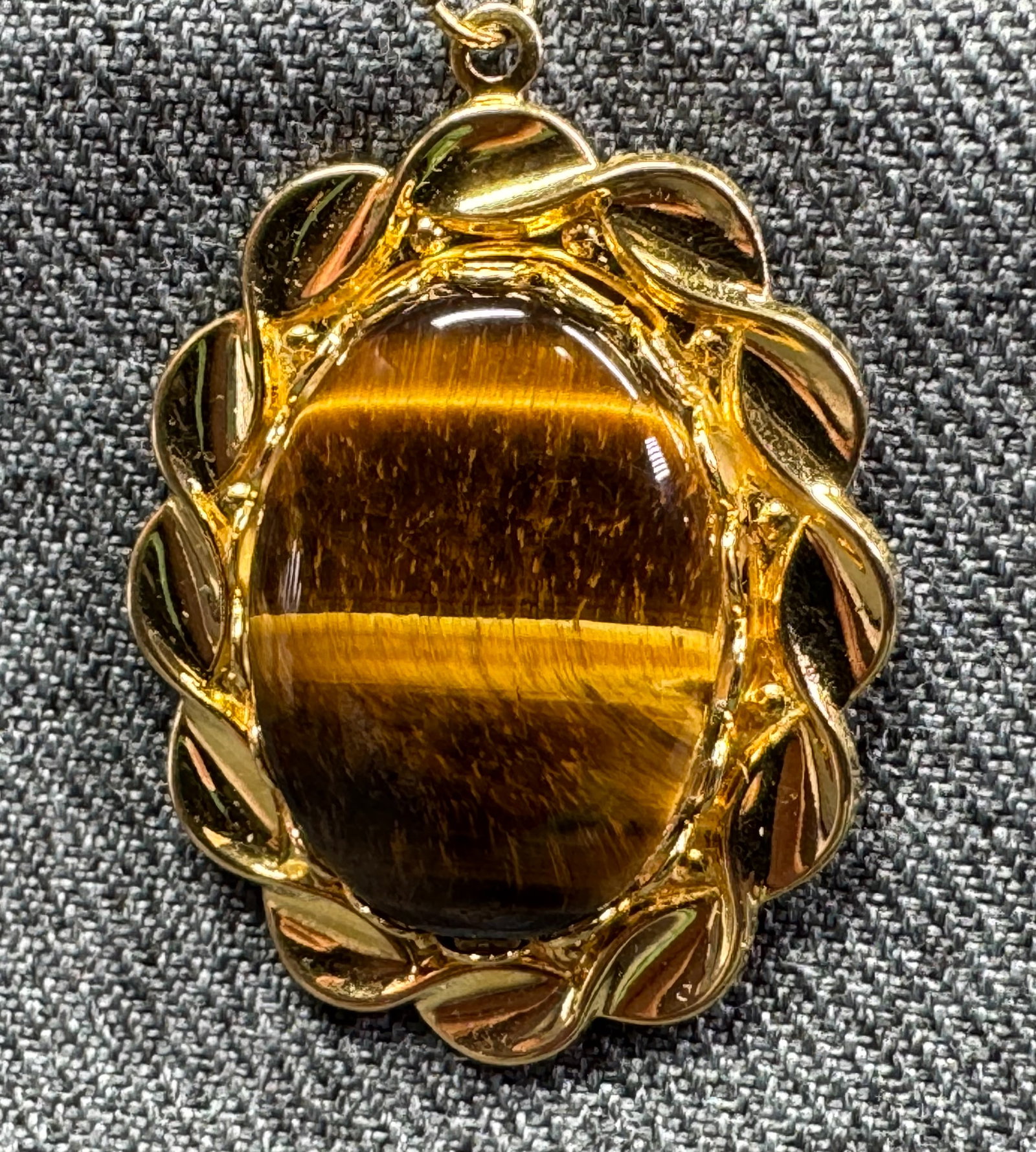 Vintage tiger eye stone goldtoned metal pendant: Vintage tiger eye stone goldtoned metal pendant. Unmarked. For measures please refer to the pictures taken with a measuring tape. Weight: 9 Grams. IN HOUSE Estimated* SHIPPING & HANDLING COST WITHIN T