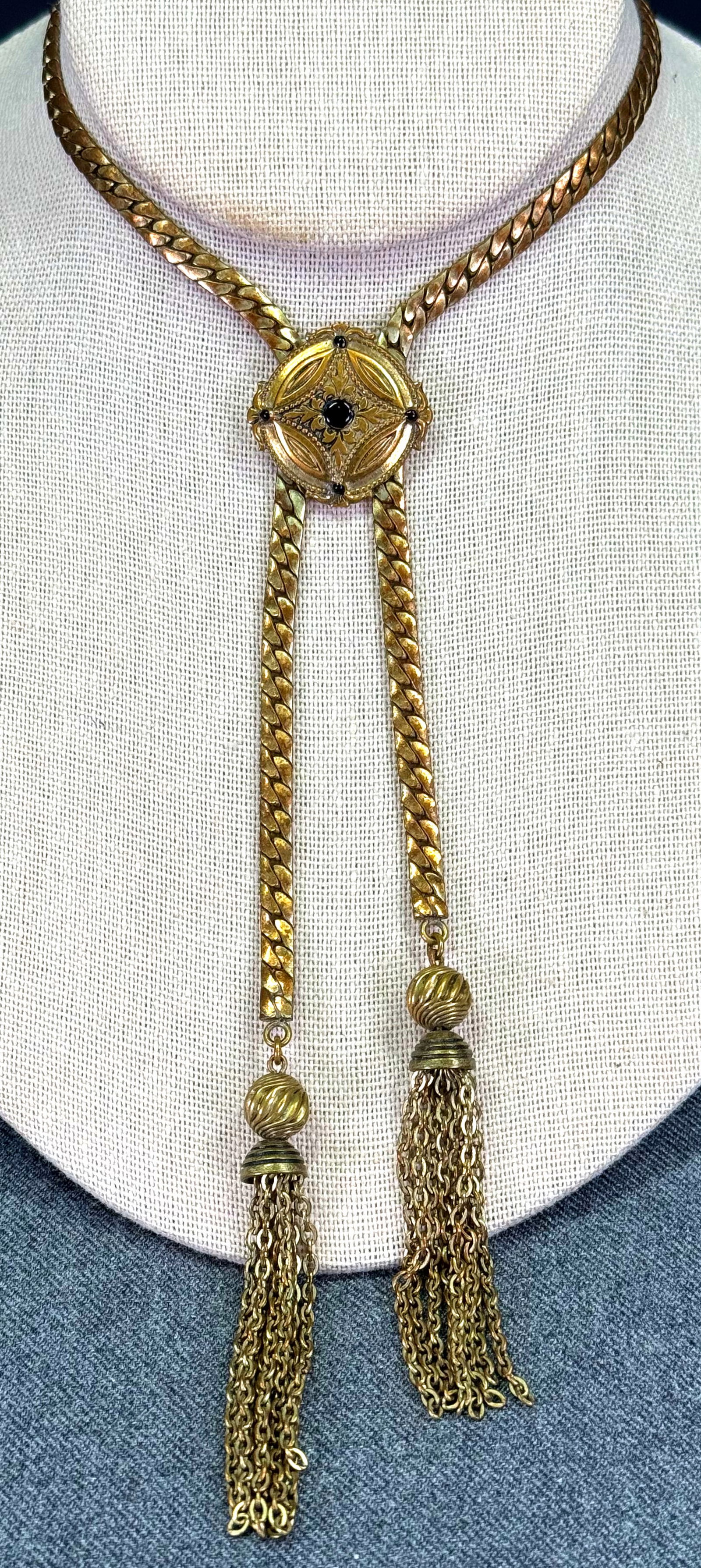 Vintage black enamel dots rounded medallion goldtone lariat necklace with tassels: Vintage black enamel dots rounded medallion goldtone lariat necklace with tassels. Unmarked. The medallion does not slides. For measures please refer to the pictures taken with a measuring tape. Weigh