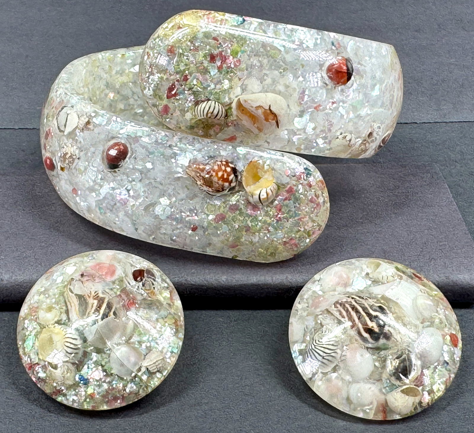 Vintage confetti and real shells inlaid lucite clamper bracelet and clip on earrings.: Vintage confetti and real shells inlaid lucite clamper bracelet and clip on earrings. Unmarked. For measures please refer to the pictures taken with a measuring tape. Weight: 50 Grams. This is a NO RE