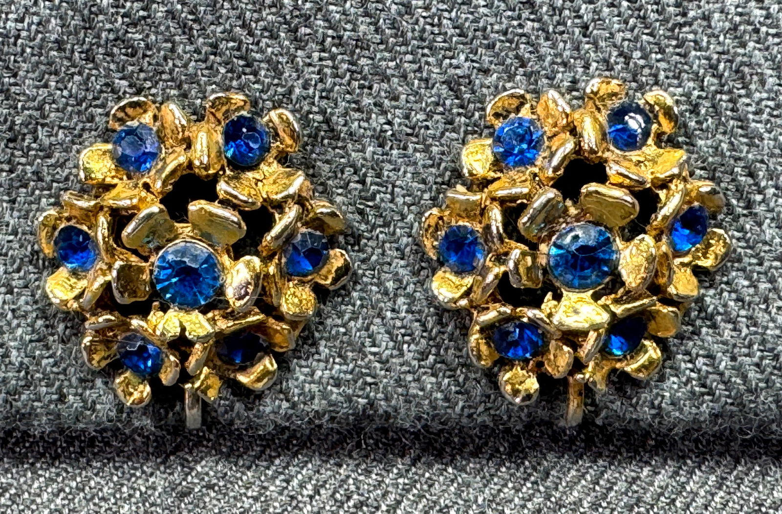 Vintage blue crystals gold-toned metal flowers clip earrings: Vintage blue crystals gold-toned metal flowers clip earrings. Unmarked. For measures please refer to the pictures taken with a measuring tape. Weight:15 Grams. IN HOUSE FLAT SHIPPING & HANDLING COST W