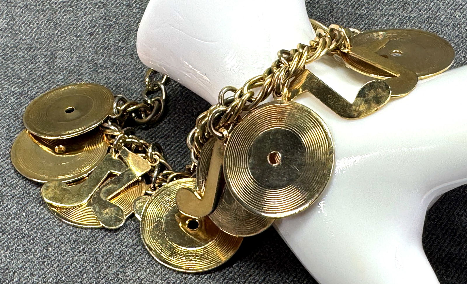 Vintage music days vinyl & quiver charms chain bracelet: Vintage music days gold-toned vinyl & quiver charms chain bracelet. Unmarked For measures please refer to the pictures taken with a measuring tape. Weight: 42 Grams. For measures please refer to the p