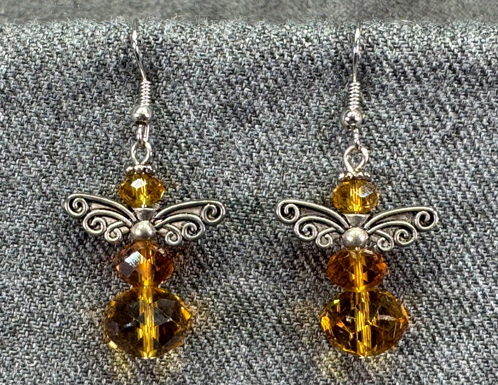 Vintage silver-toned metal wings amber crystal angel hook earrings: Vintage silver-toned metal wings amber color crystal angel hook earrings. Unmarked. For measures please refer to the pictures taken with a measuring tape. Weight: 7Grams. IN HOUSE FLAT SHIPPING & HAND