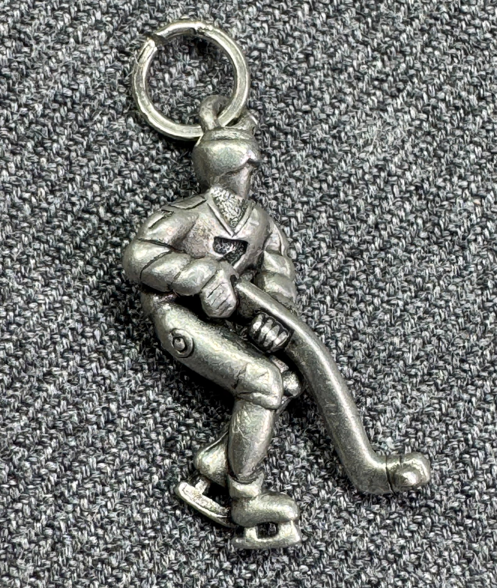 Vintage ice hockey player silver-toned charm pendant: Vintage ice hockey player silver-toned charm pendant. Unmarked. For measures please refer to the pictures taken with a measuring tape. Weight: 1.77 Grams. IN HOUSE FLAT SHIPPING & HANDLING COST WITHIN