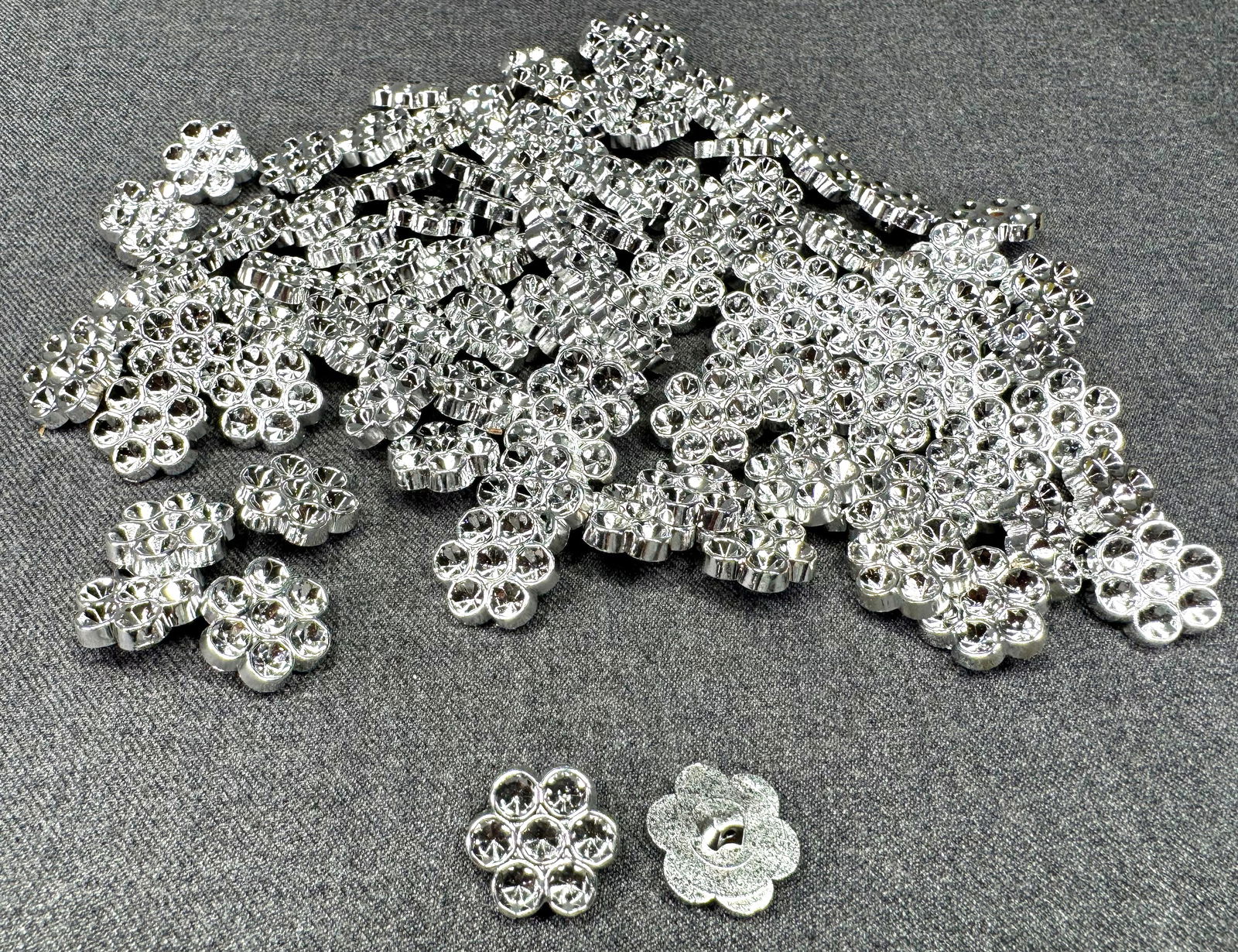 Vintage silver plastic 6 petals flower buttons. 100 pcs. Unused. Space for crystals: Vintage silver plastic 6 petals flower buttons. 100 pcs Unused. Space for crystals or sew on as is. For measures please refer to the pictures taken with a measuring tape. Weight:70 Grams. IN HOUSE FLA