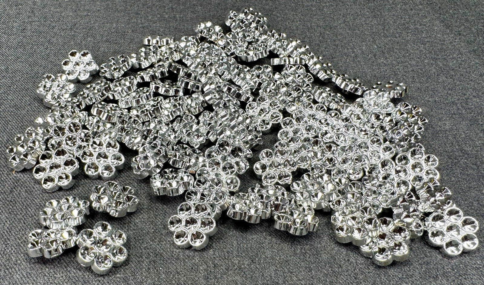 Vintage silver plastic 5 petals flower buttons. 100 pcs. Unused. Space for crystals: Vintage silver plastic 6 petals flower buttons. 100 pcs Unused. Space for crystals or sew on as is. For measures please refer to the pictures taken with a measuring tape. Weight: 37 Grams. IN HOUSE FL