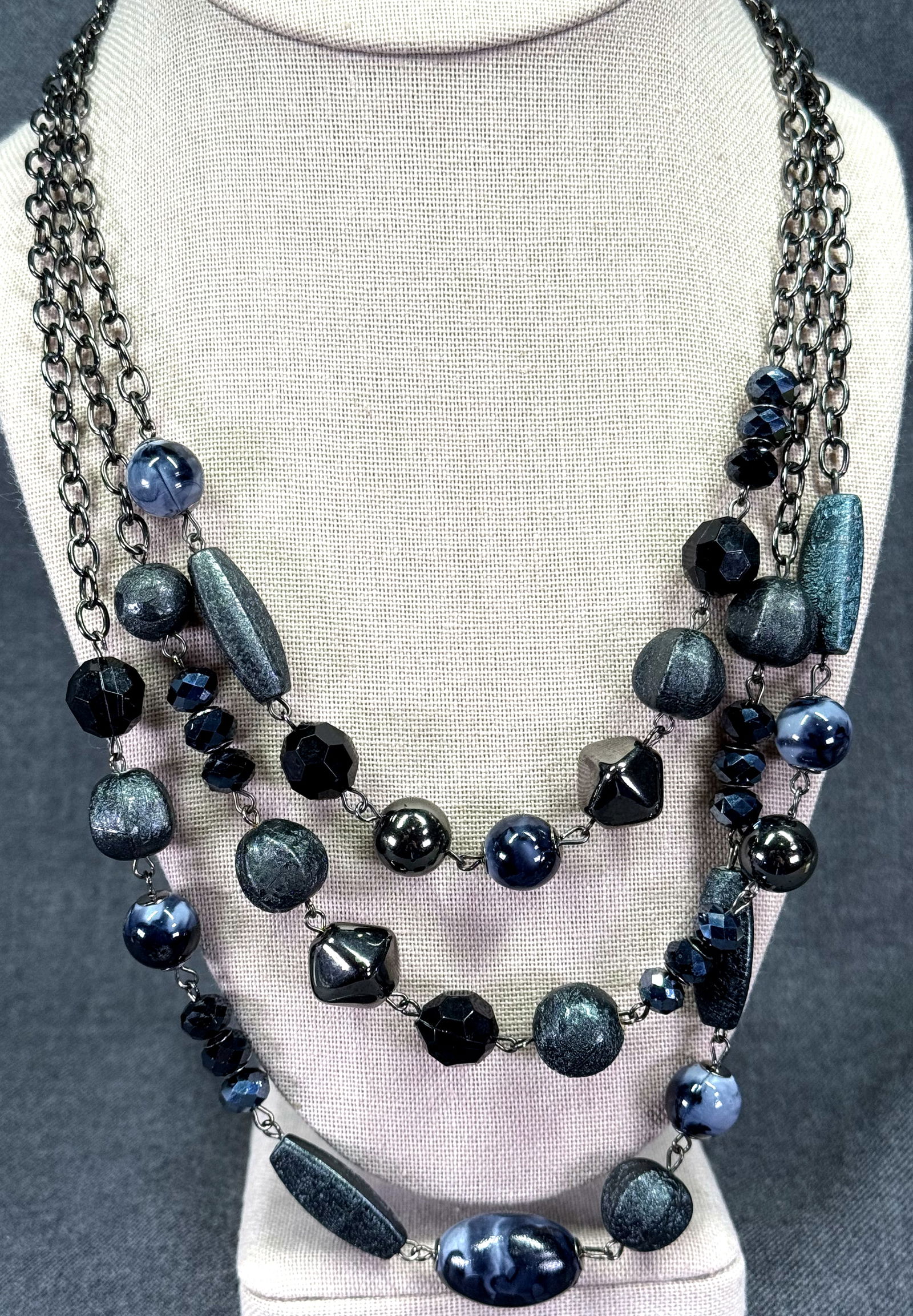 Assorted grayish & black plastic beads gunmetal 3 strands bib necklace: Assorted grayish & black plastic beads gunmetal 3 strands bib necklace. Unmarked. For measures please refer to the pictures taken with a measuring tape. Weight: 60 Grams . IN HOUSE FLAT SHIPPING & HAN