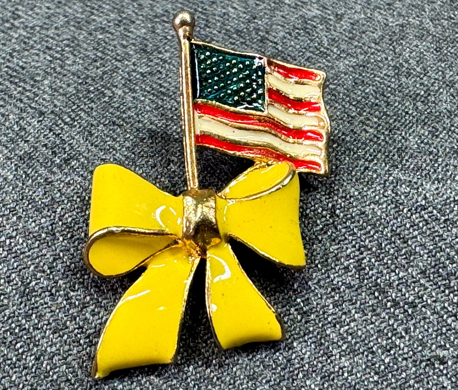 Vintage USA American Flag & Support Our Troops yellow bow lapel pin . #a: Vintage USA American Flag & Support Our Troops yellow bow lapel pin. Enamel gold-toned metal . Unmarked. For measures please refer to the pictures taken with a measuring tape. Weight: 6 Grams. IN HOUS