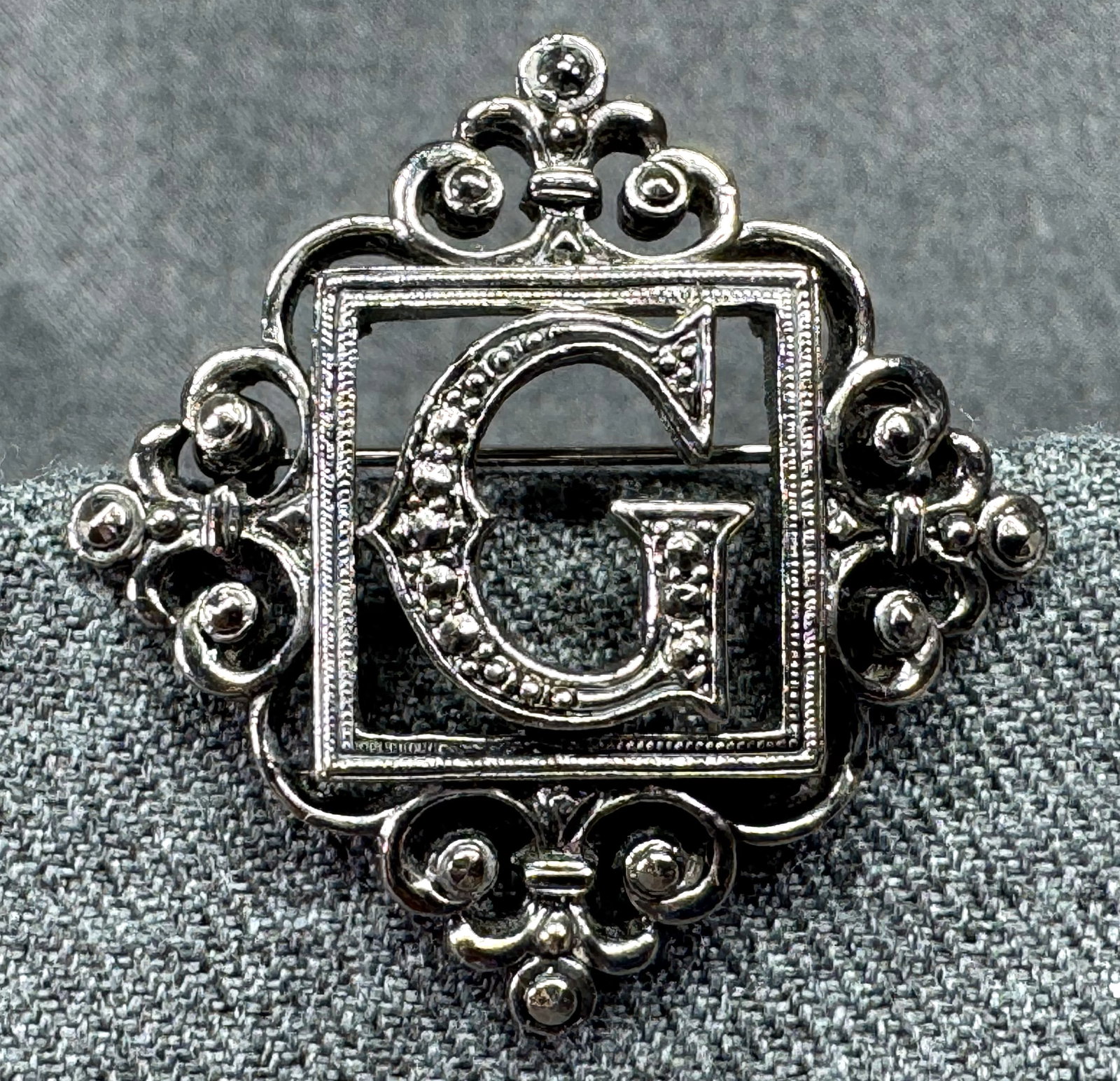 Vintage filigree silver-toned metal initial G brooch pin . *a: Vintage filigree silver-toned metal initial G brooch pin . Unmarked. For measures please refer to the pictures taken with a measuring tape. Weight: 10 Grams IN HOUSE FLAT SHIPPING & HANDLING COST WITH