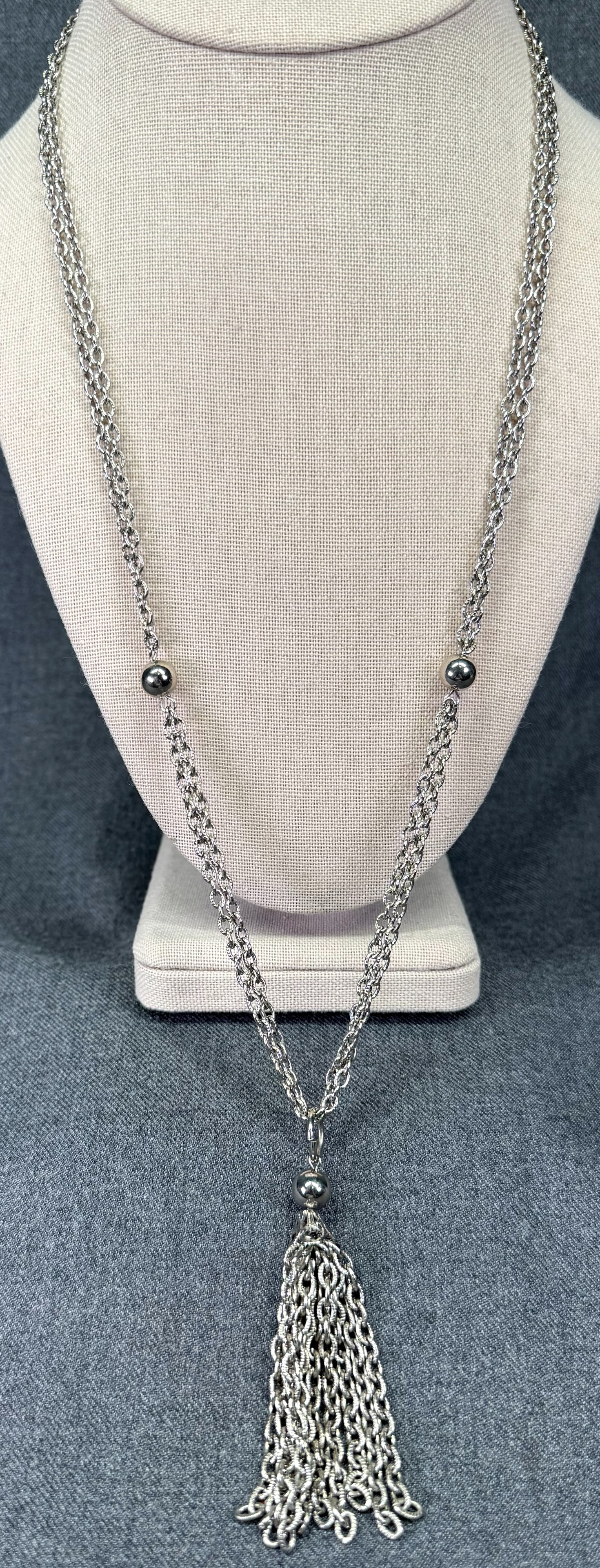 Vintage silver-toned lariat necklace with tassel. *c: Vintage silver-toned lariat necklace with tassel. Unmarked. For measures please refer to the pictures taken with a measuring tape. Weight: 32 Grams. IN HOUSE FLAT SHIPPING & HANDLING COST WITHIN ALL T