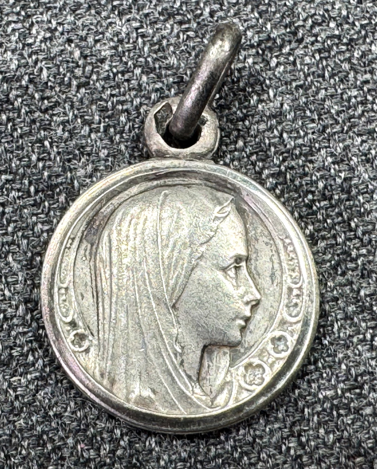 Vintage Our Lady of Lourdes sterling silver medal charm. Signed: Vintage Our Lady of Lourdes sterling silver charm medal. Unreadable signature on the bottom rim of the back side. Rombus Mark for sterling on the bail. For measures please refer to the pictures taken