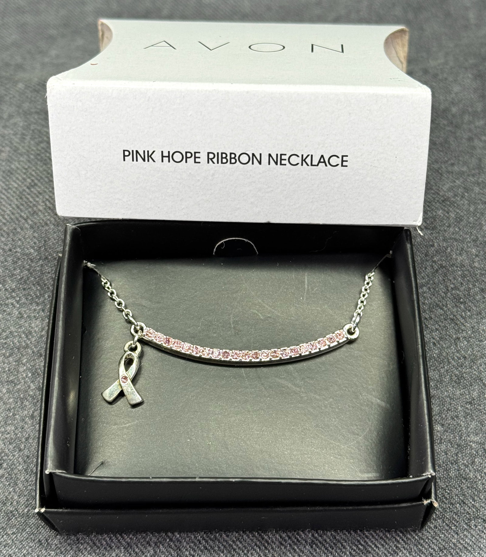 2019 Avon Breast Cancer Awareness Pink Hope Ribbon silver-tone necklace in box. *d: 2019 Avon Breast Cancer Awareness Pink Hope Ribbon silver-tone necklace in box. Marked. For measures please refer to the pictures taken with a measuring tape. Weight: 15 Grams. IN HOUSE FLAT SHIPPING