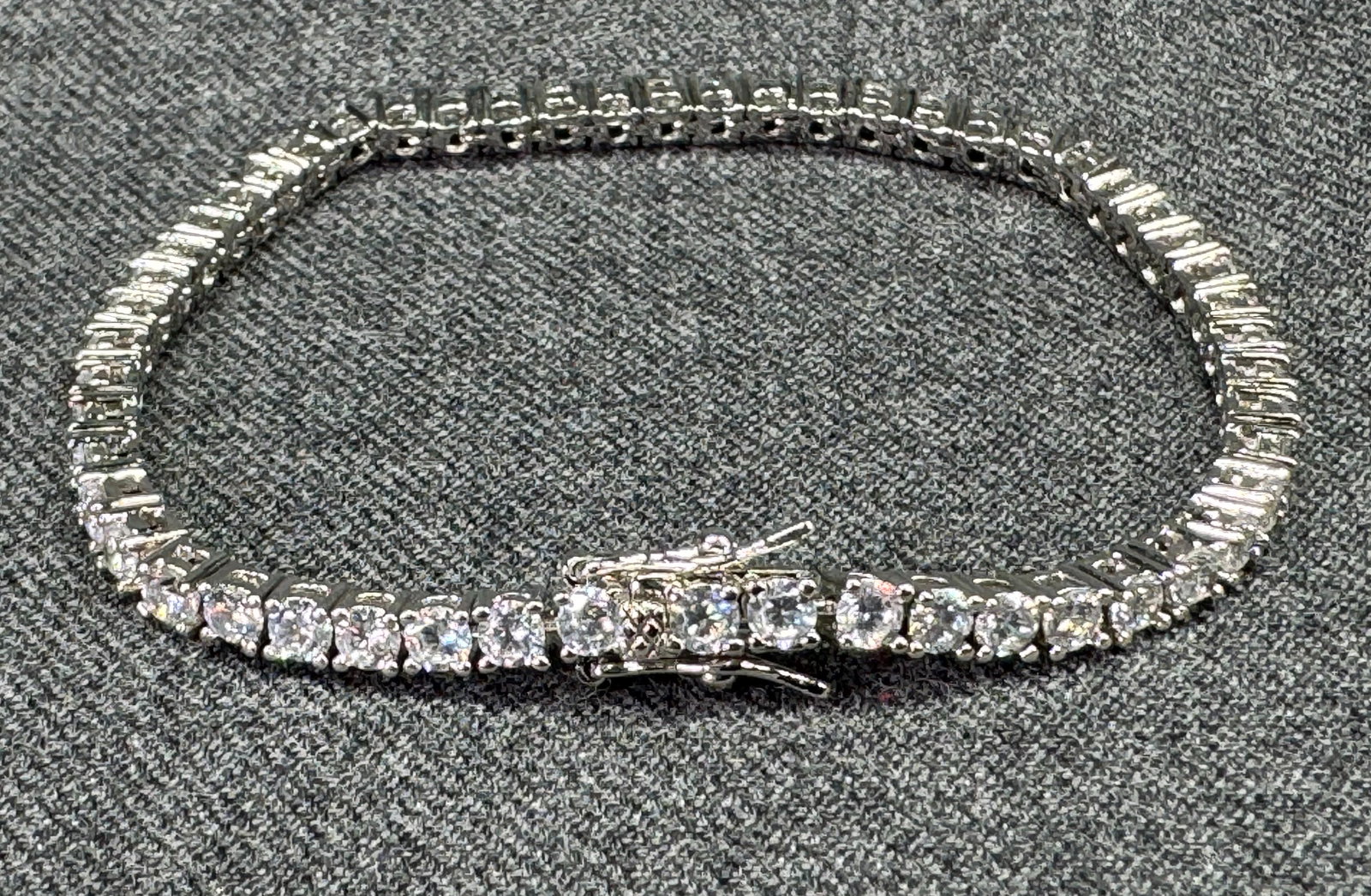 Silver-Tone Cubic Zirconia Tennis Bracelet. Marked CC. *f: Silver-Tone Cubic Zirconia Tennis Bracelet. Marked CC. For measures please refer to the pictures taken with a measuring tape. Weight: 10 Grams. IN HOUSE FLAT SHIPPING & HANDLING COST WITHIN ALL THE U.