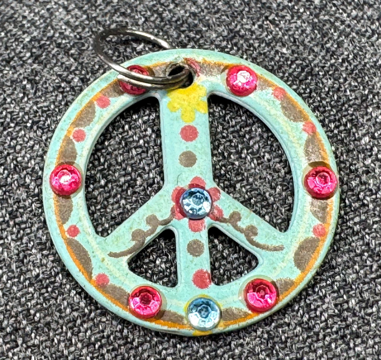 Vintage jeweled & painted metal peace sign charm pendant. *c: Vintage jeweled & painted metal peace sign charm pendant. Unmarked. For measures please refer to the pictures taken with a measuring tape. Weight: 2 Grams IN HOUSE FLAT SHIPPING & HANDLING COST WITHIN