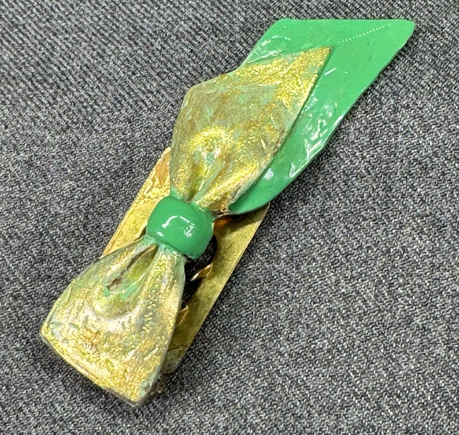 Antique painted green & golden ribbons in bow dress brooch. *c: Antique painted green & golden ribbons in bow dress brooch.Unmarked. For measures please refer to the pictures taken with a measuring tape. Weight: 20 Grams. IN HOUSE FLAT SHIPPING & HANDLING COST WIT