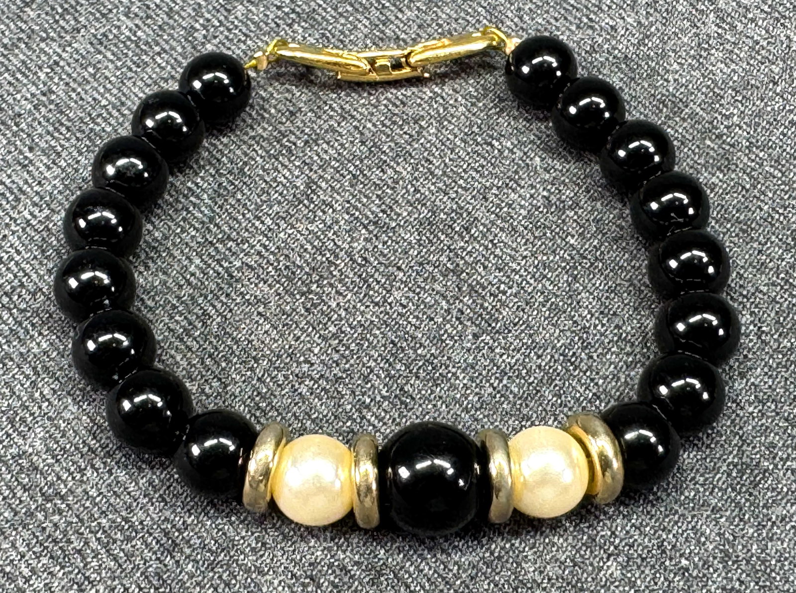 Vintage Napier black, pearly and golden beads bracelet. *a: Vintage Napier black, pearly and golden beads bracelet. Marked. For measures please refer to the pictures taken with a measuring tape. Weight: 8 Grams. IN HOUSE FLAT SHIPPING & HANDLING COST WITHIN AL