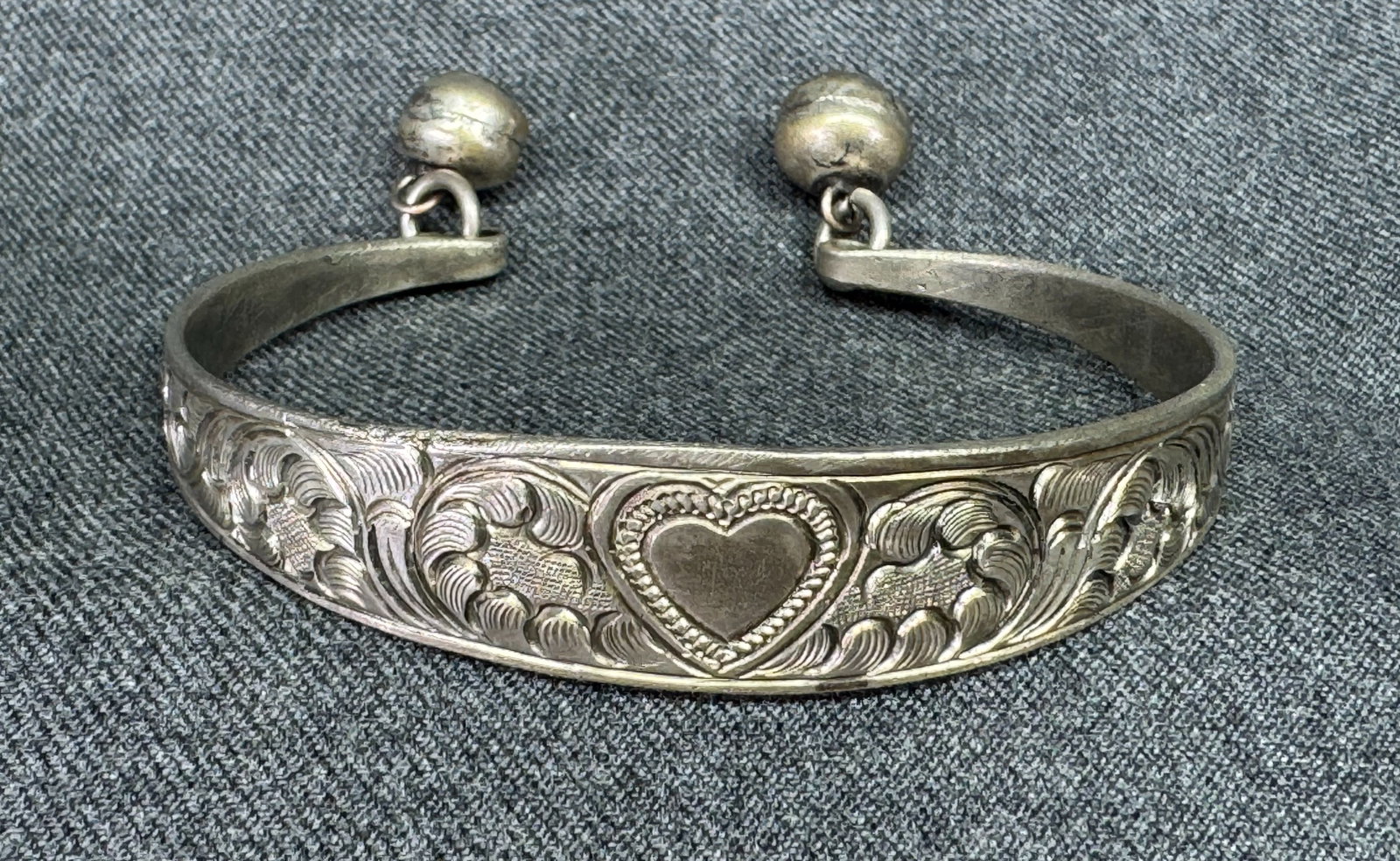 Vintage Miao Silver-tone Repoussé Floral Scroll Heart Bell Bracelet. *h: Vintage Miao Silver-tone Repoussé Floral Scroll Heart Bell Bracelet.Unmarked. For measures please refer to the pictures taken with a measuring tape. Weight: 22 Grams. IN HOUSE FLAT SHIPPING & HAN