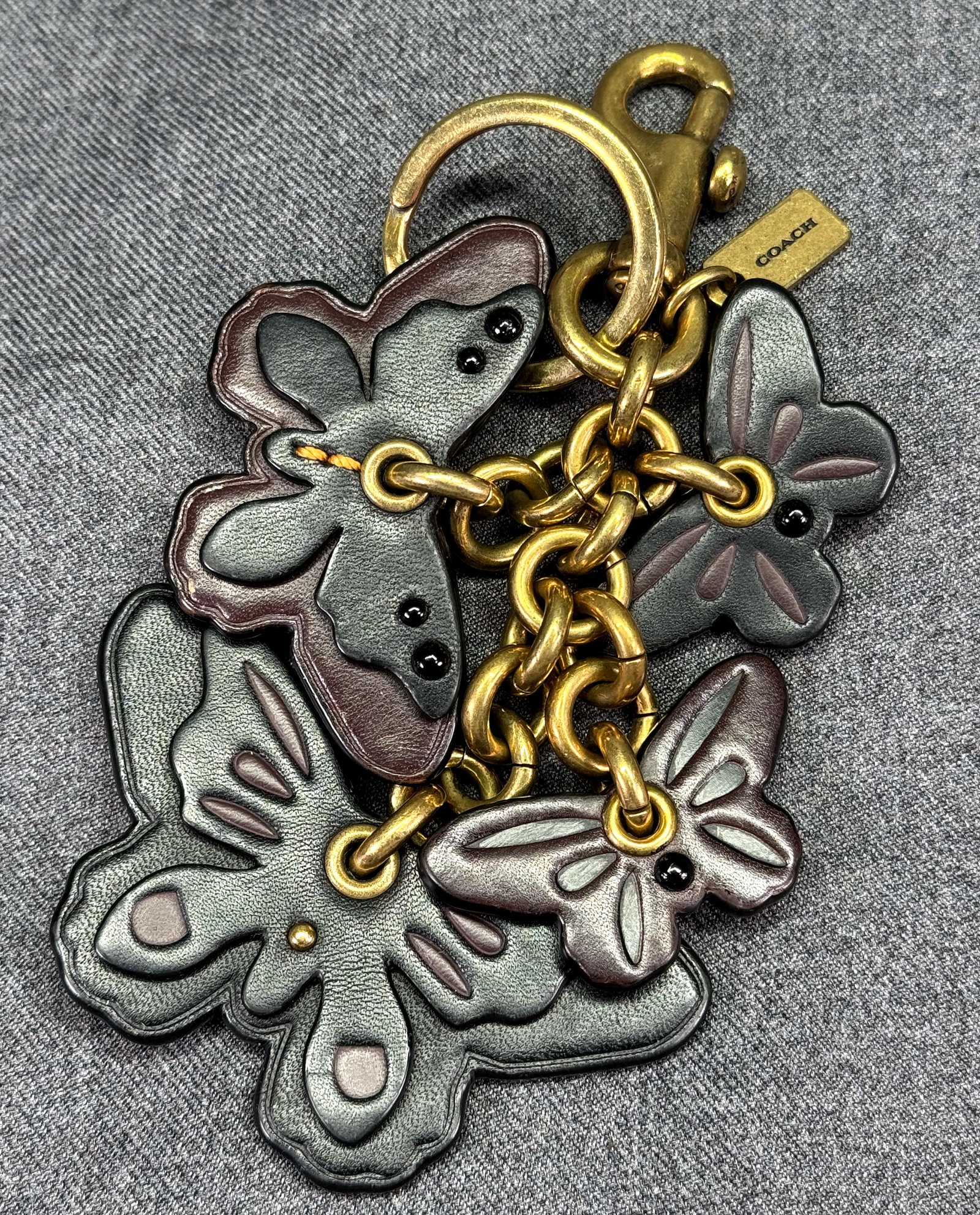 Coach Butterfly Cluster Bag Charm. Attached split key ring and dogleash clip. *f: Coach Butterfly Cluster Bag Charm. Attached split key ring and dogleash clip. Marked. For measures please refer to the pictures taken with a measuring tape. Weight: 20 Grams. IN HOUSE FLAT SHIPPING & 