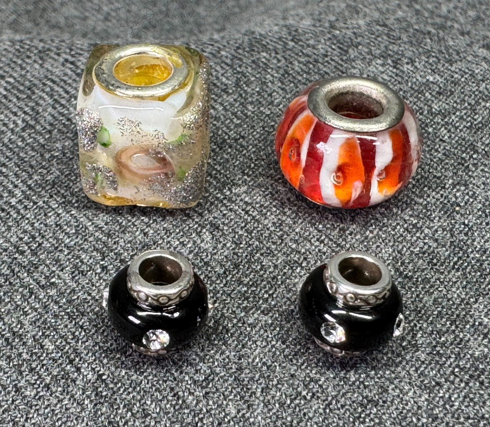 Vintage artisan assorted glass silver rim beads charms. Lot of 4: Vintage artisan assorted glass silver rim beads charms. Lot of 4. Unmarked. For measures please refer to the pictures taken with a measuring tape. Weight: 7 Grams IN HOUSE FLAT SHIPPING & HANDLING COS