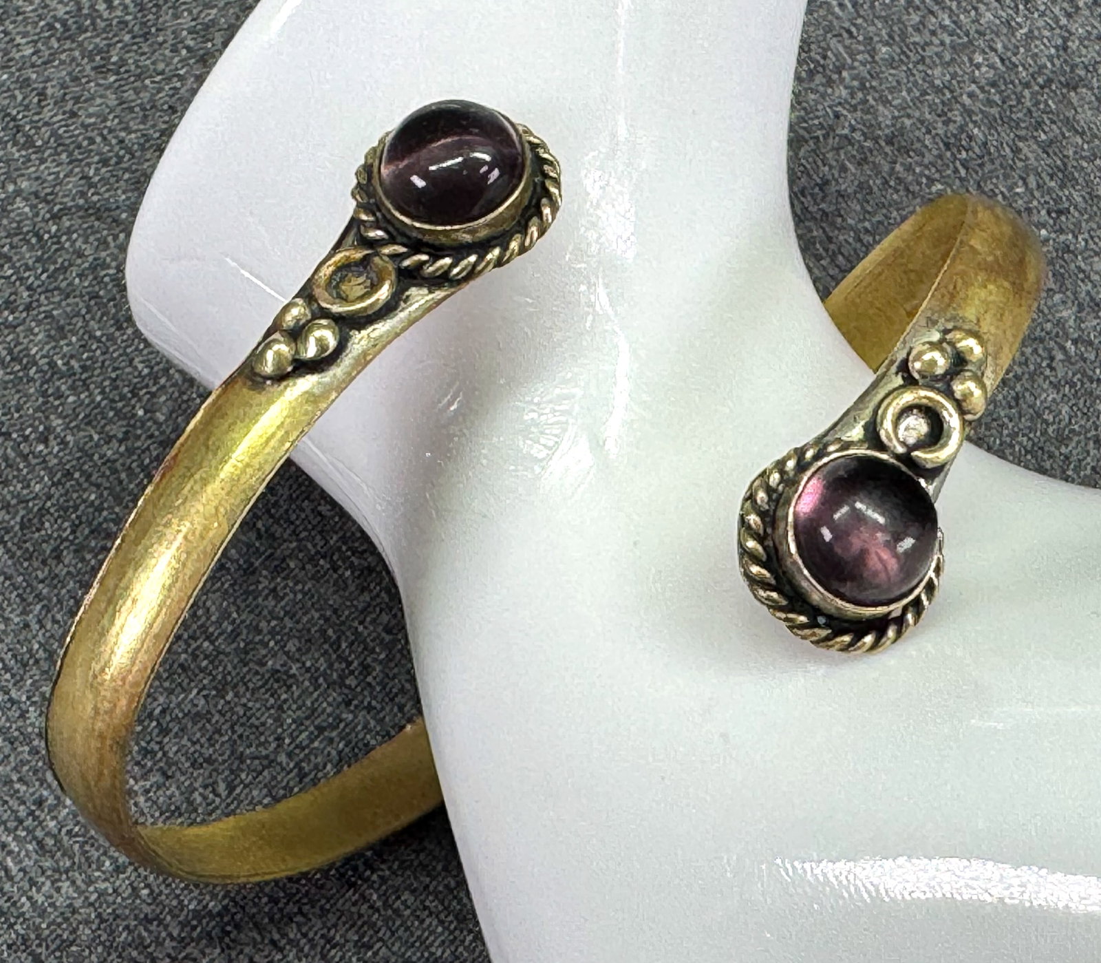 Vintage Brass Bypass Cuff Bracelet with Faux Amethyst Cabochons. *K: Vintage Brass Bypass Cuff Bracelet with Faux Amethyst Cabochons. Unmarked. For measures please refer to the pictures taken with a measuring tape. Weight: 12 Grams. IN HOUSE FLAT SHIPPING & HANDLING CO