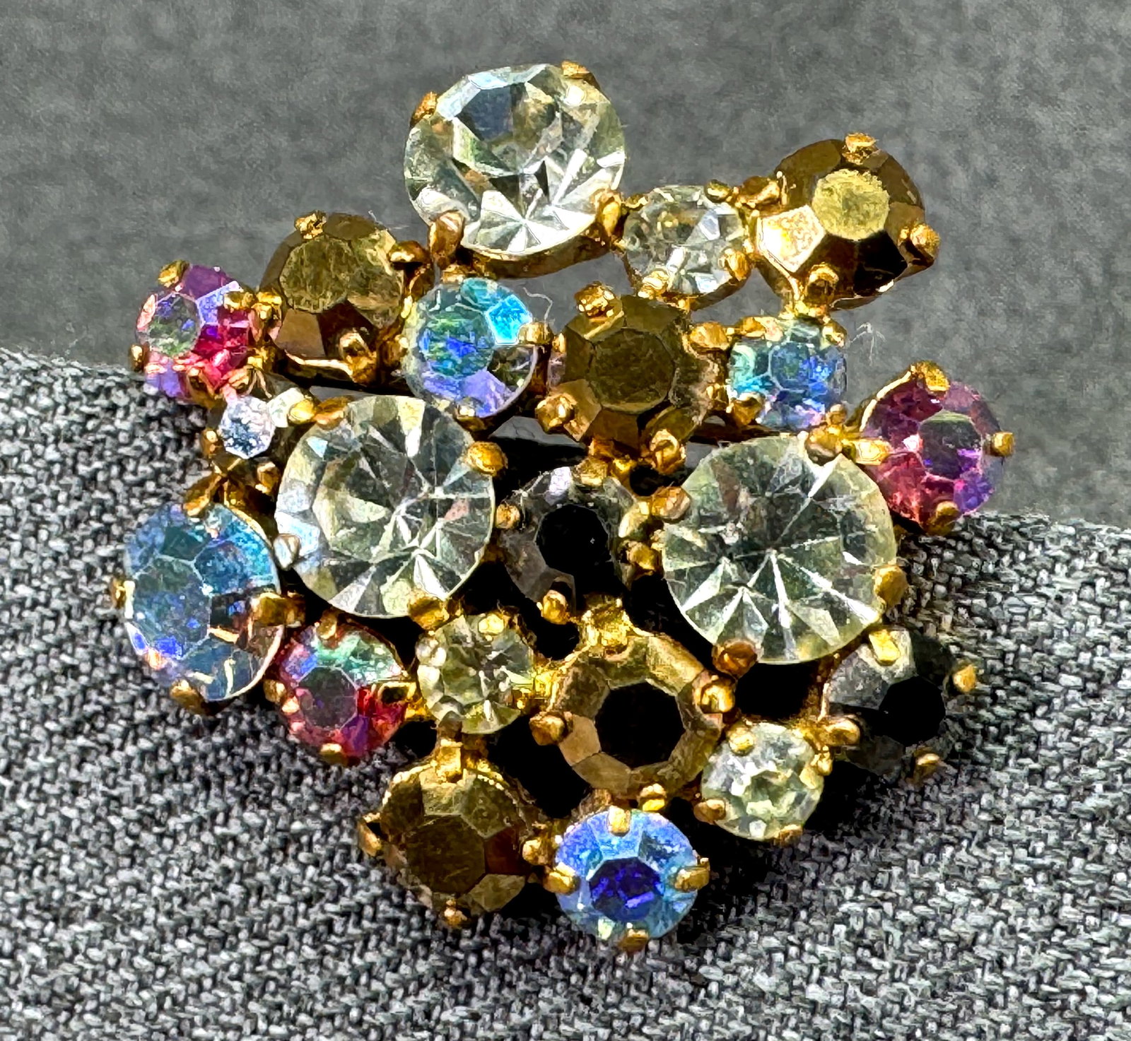 Vintage Aurora Borealis Crystal Cluster Vintage Brooch. Gold-tone. *i: Vintage Aurora Borealis Crystal Cluster Vintage Brooch. Gold-tone. Unmarked For measures please refer to the pictures taken with a measuring tape. Weight: 9 Grams. IN HOUSE FLAT SHIPPING & HANDLING CO