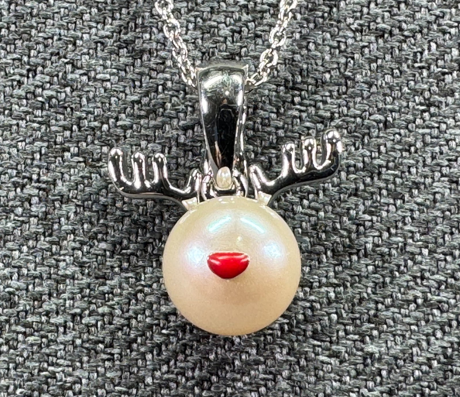 Reindeer Christmas Enhancer Pendant Necklace. Sterling Silver, Freshwater Pearl. Red Enamel. *K: Sterling Silver Reindeer Freshwater Pearl Christmas Enhancer Pendant Necklace". Marked on pendant & chain. For measures please refer to the pictures taken with a measuring tape. Weight: Grams. IN HOUS
