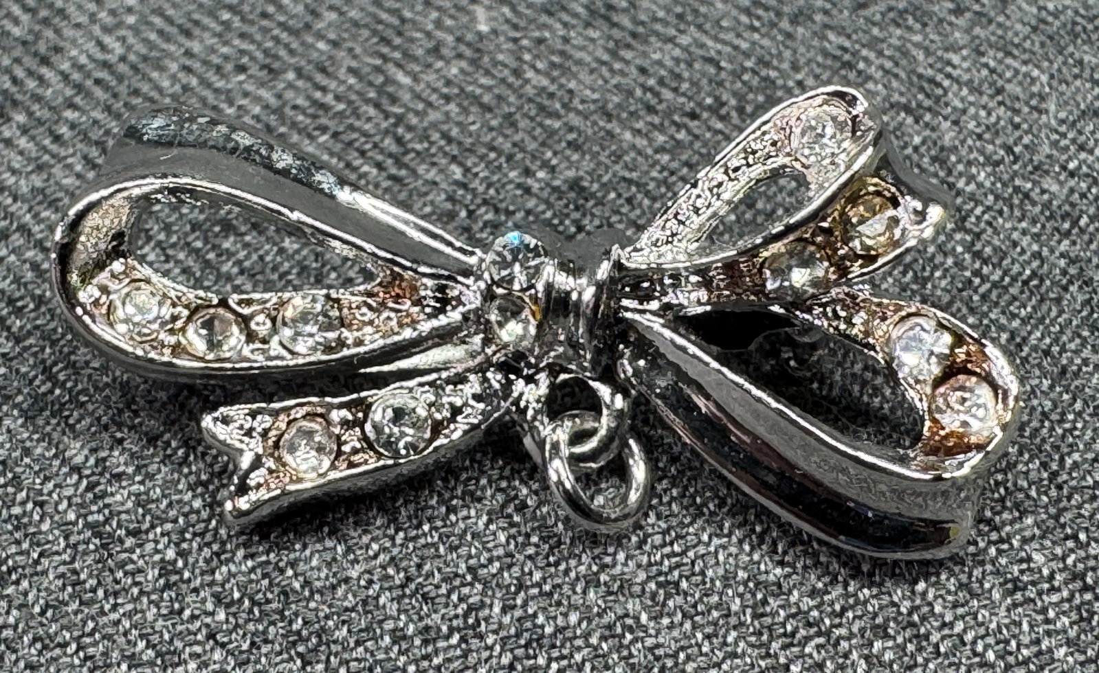 Vintage clear rhinestones silver-toned bow brooch pin with a ring for a dangle . *a: ViVintage clear rhinestones silver-toned bow brooch pin with a ring for a dangle . Unmarked. For measures please refer to the pictures taken with a measuring tape. Weight: 10 7Grams IN HOUSE FLAT SHIP